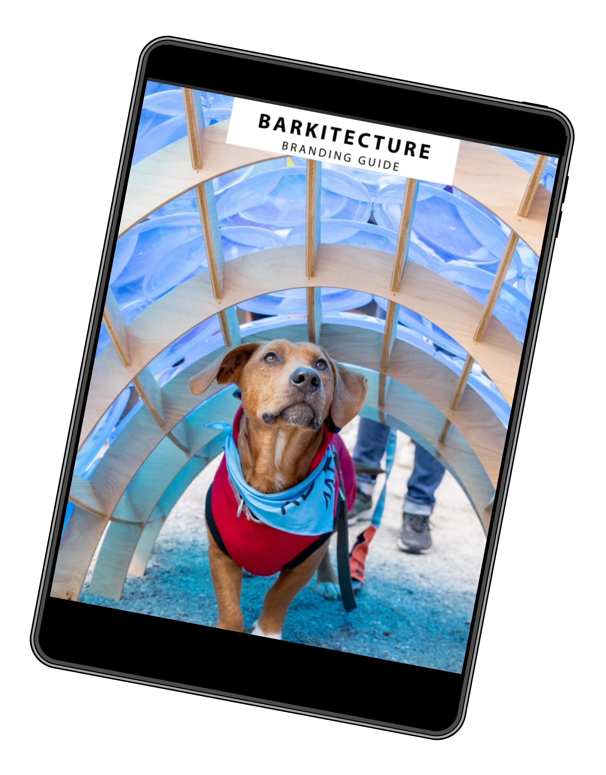 A dog wearing a red vest and blue bandana standing under a wooden and glass structure at an event. A sign reads "BARKITECTURE BRANDING GUIDE."