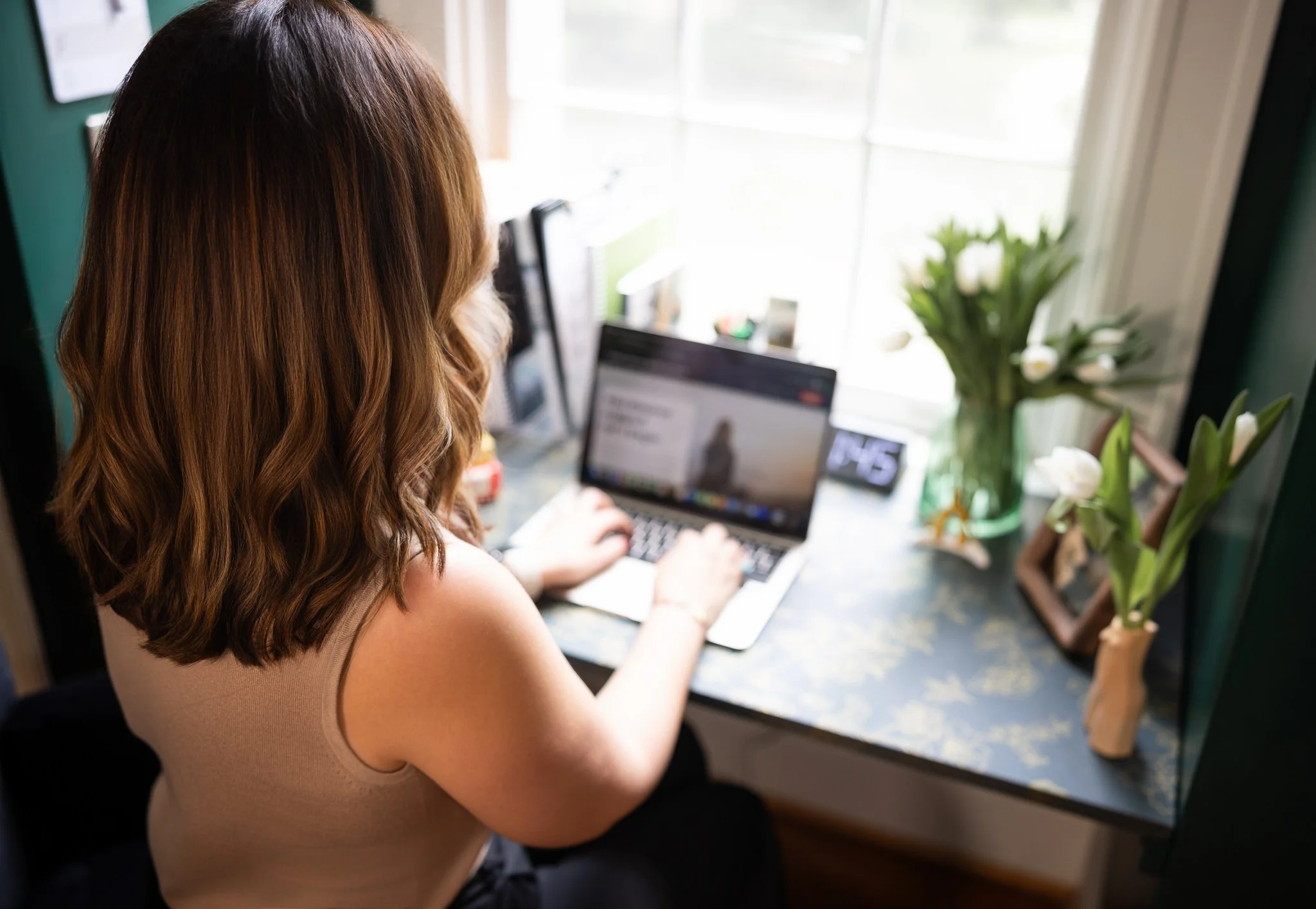 A photo of a therapist typing on her laptop engaging in blog writing.