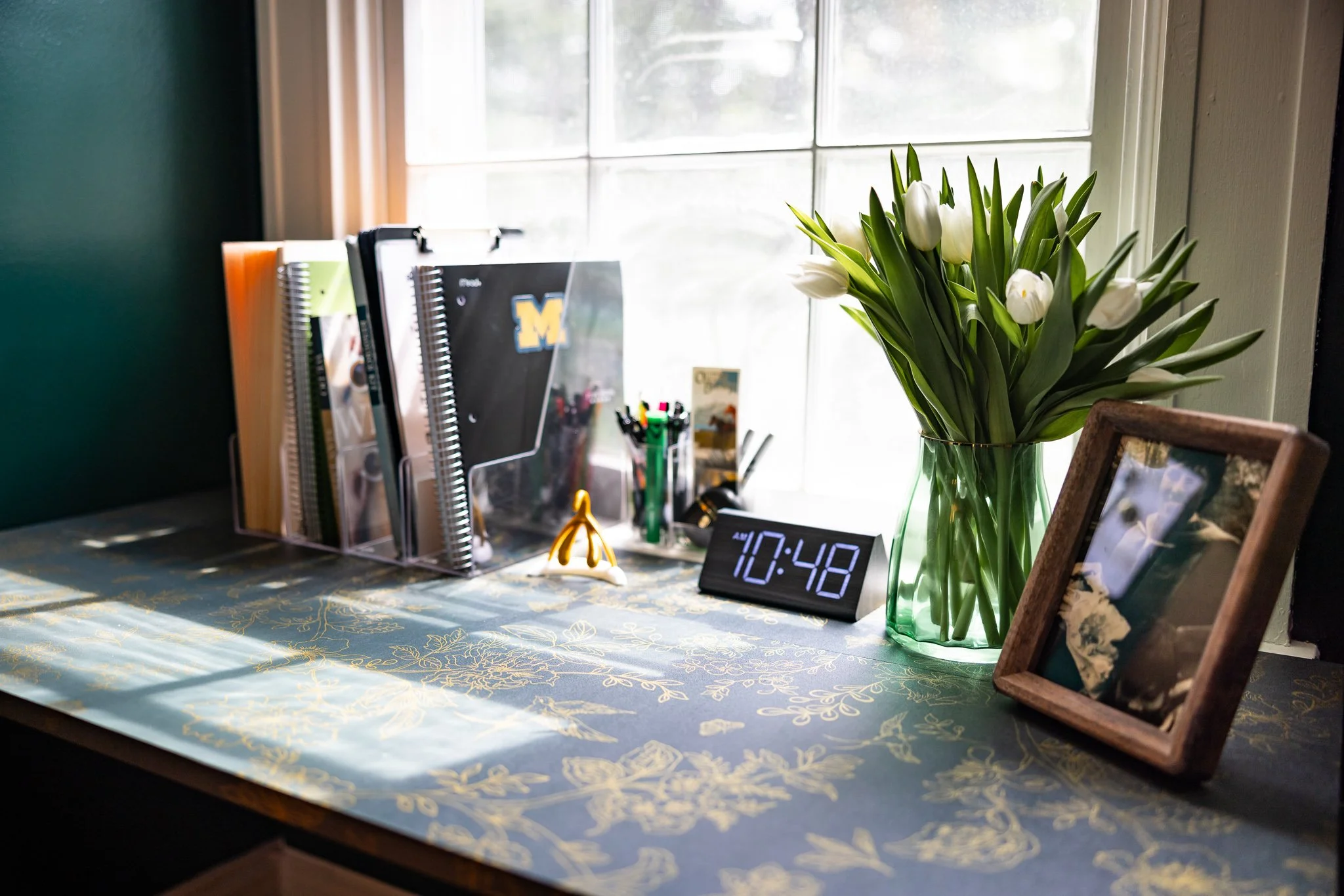 Picture of a modern individual and couples therapist's desk with fresh flowers and warm light.