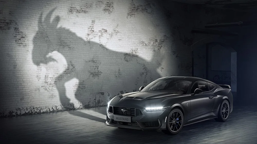 A Ford Mustang in a dark room, casting a shadow of a goat
