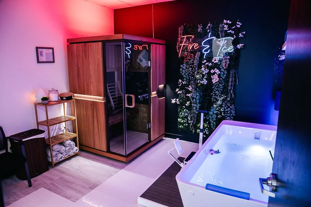 Luxury spa room with sauna, bath, neon sign, towels, and ambient lighting.