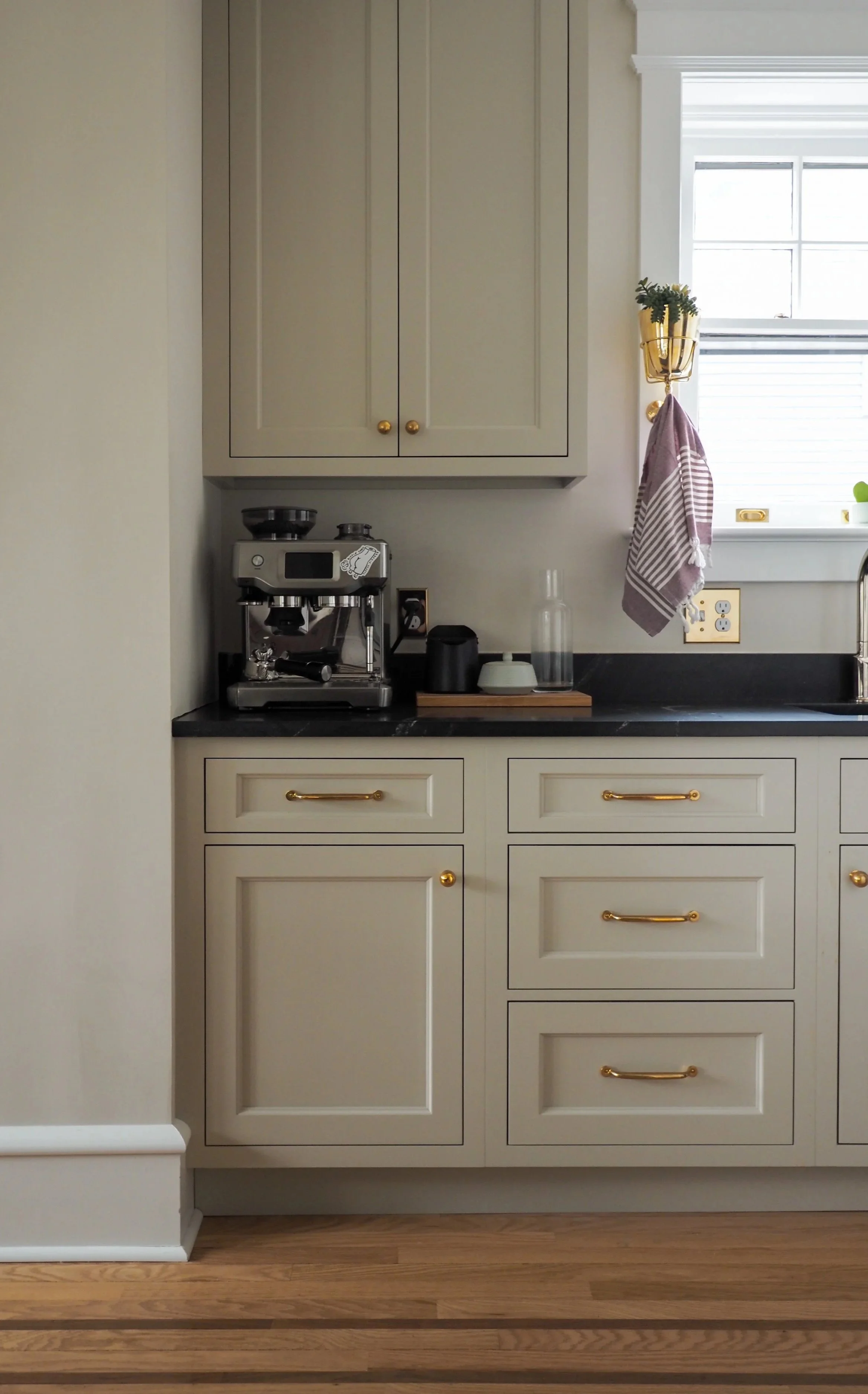 Custom coffee bar with warm grey cabinetry, prep sink, brass hardware, and black countertop — Studied Milieux kitchen design, South Jersey
