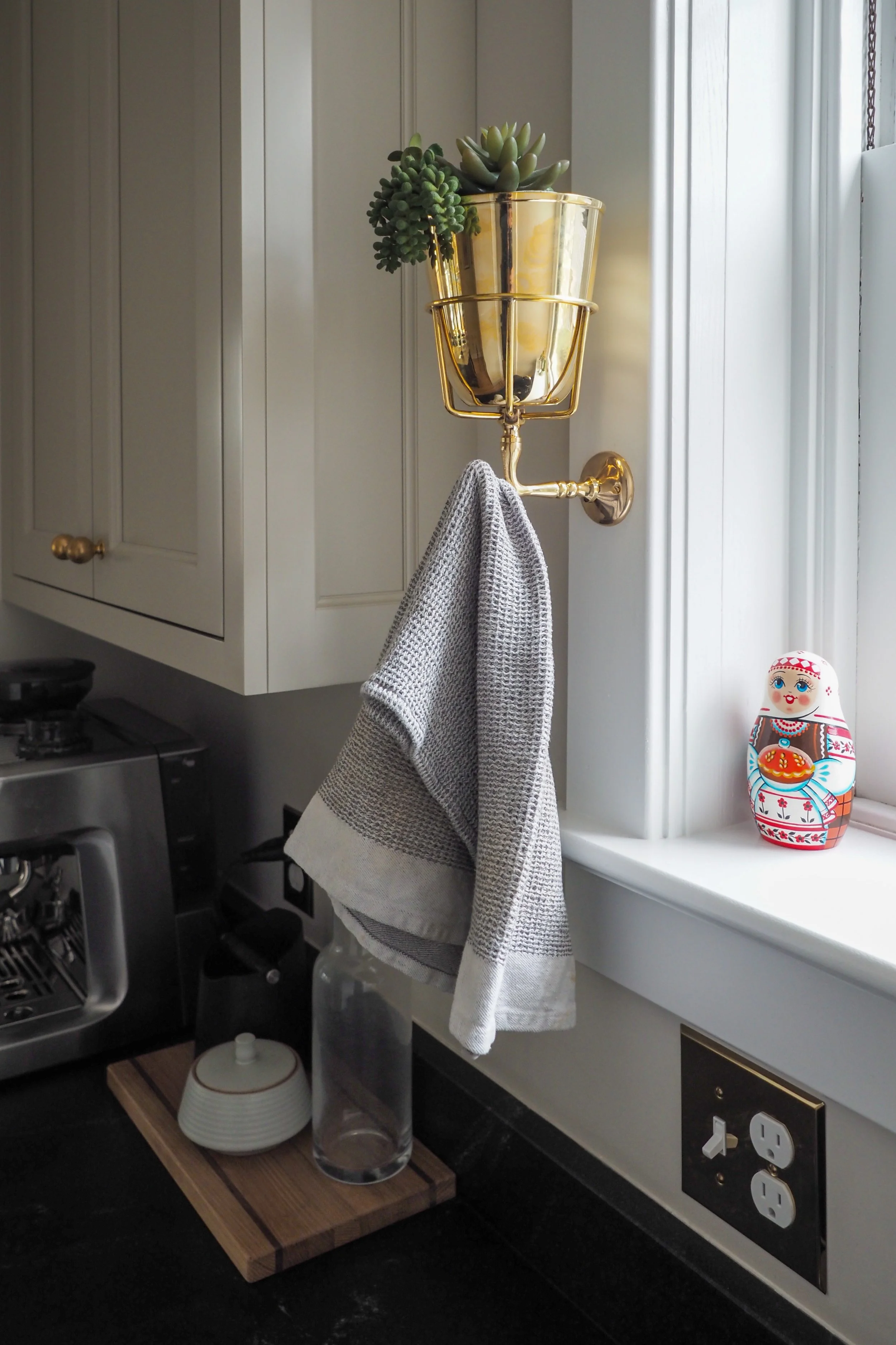 Kitchen detail with custom storage, brass fixtures, and black countertop — Studied Milieux, South Jersey interior designer