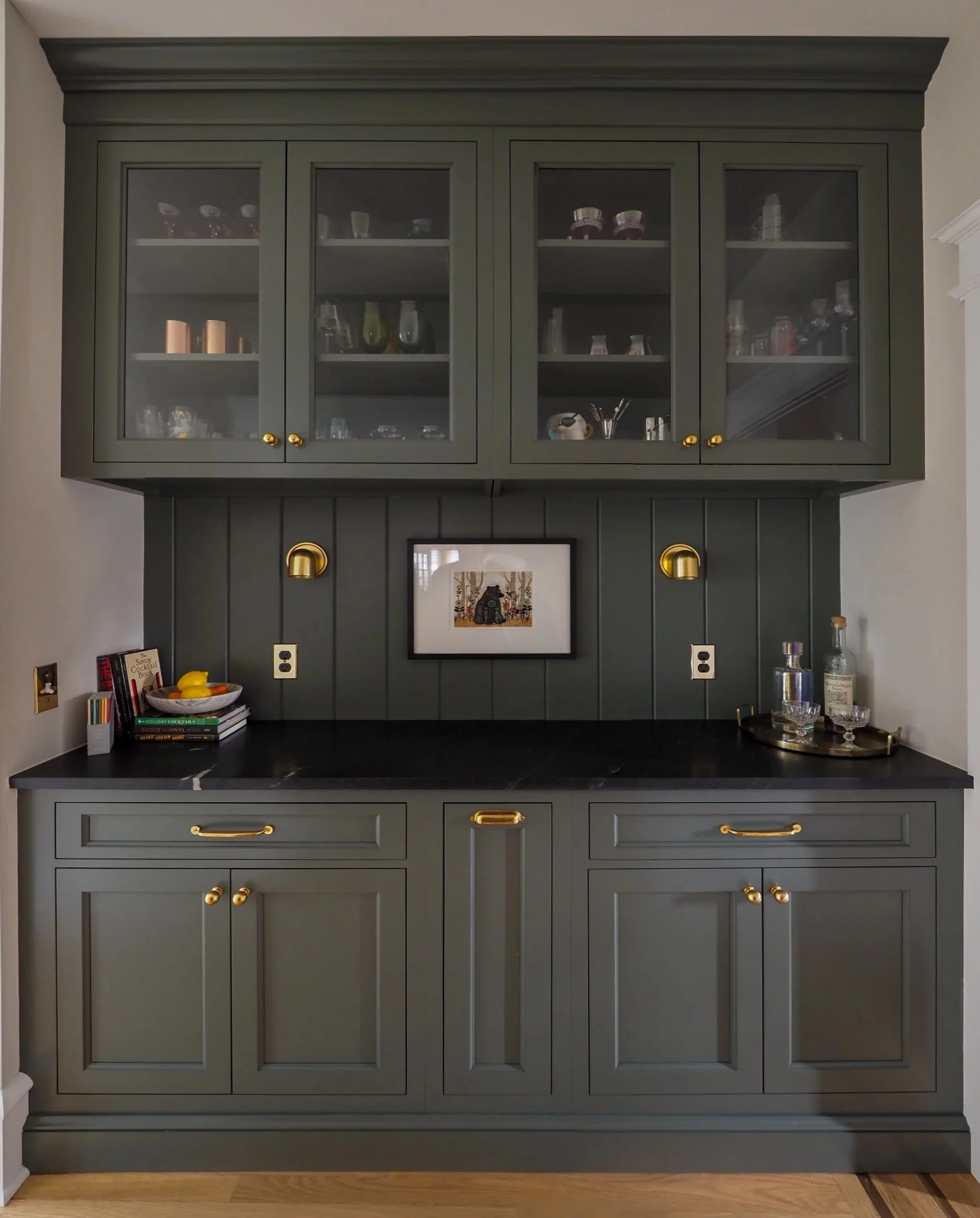 Custom dry bar with olive green cabinetry, glass front uppers, and brass hardware — Studied Milieux interior design, Haddonfield NJ