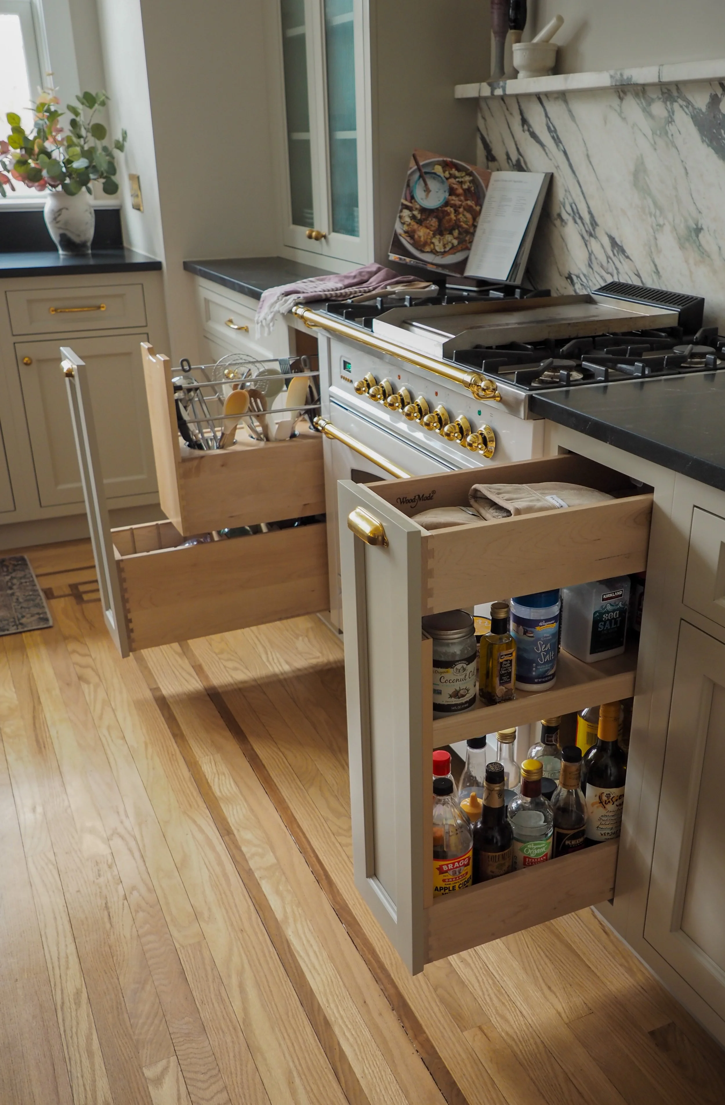 Custom pull-out storage and spice drawers next to professional range — Studied Milieux kitchen renovation, Haddonfield NJ