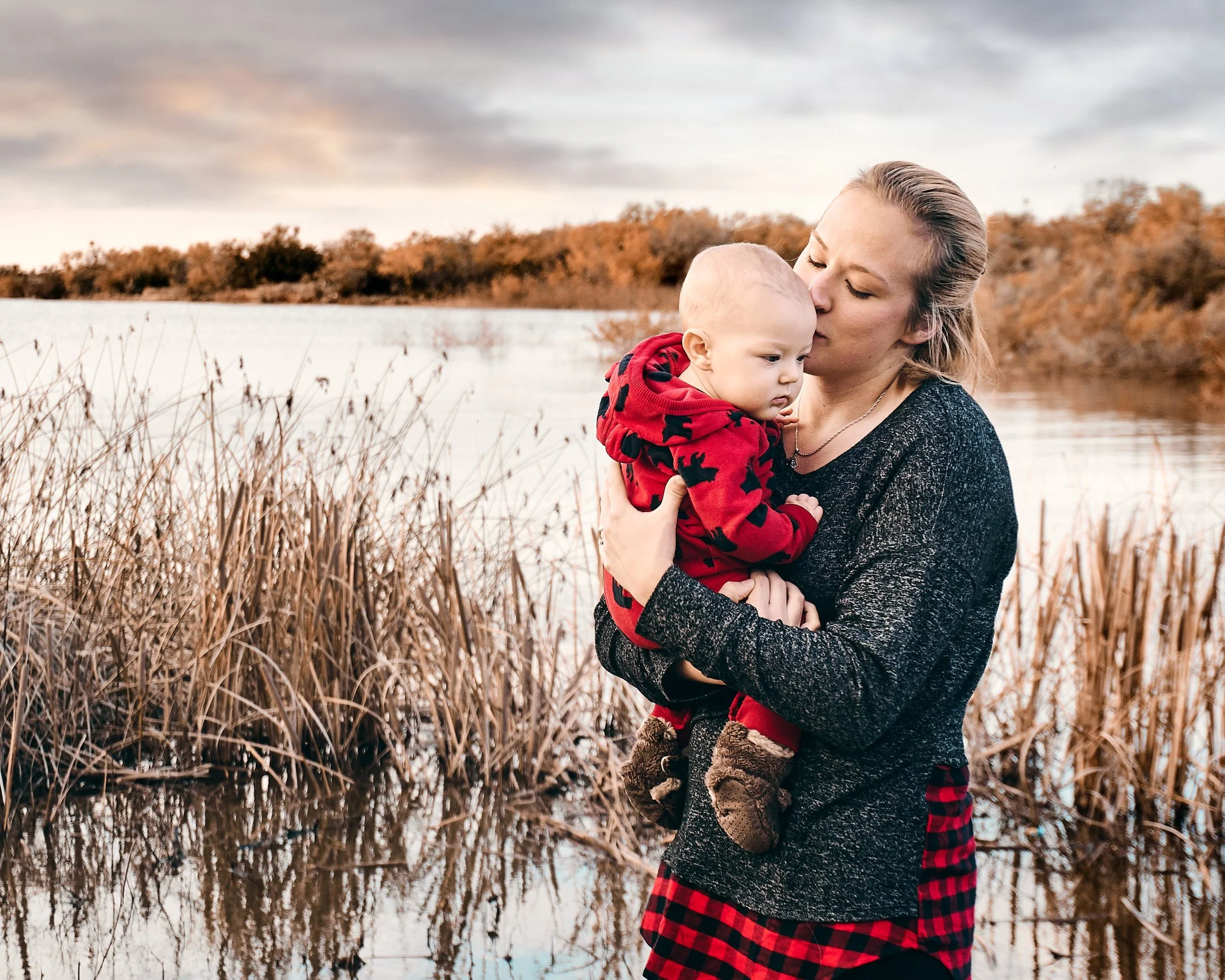 Mom Kissing baby's head in winter next to Lakejpg.jpg