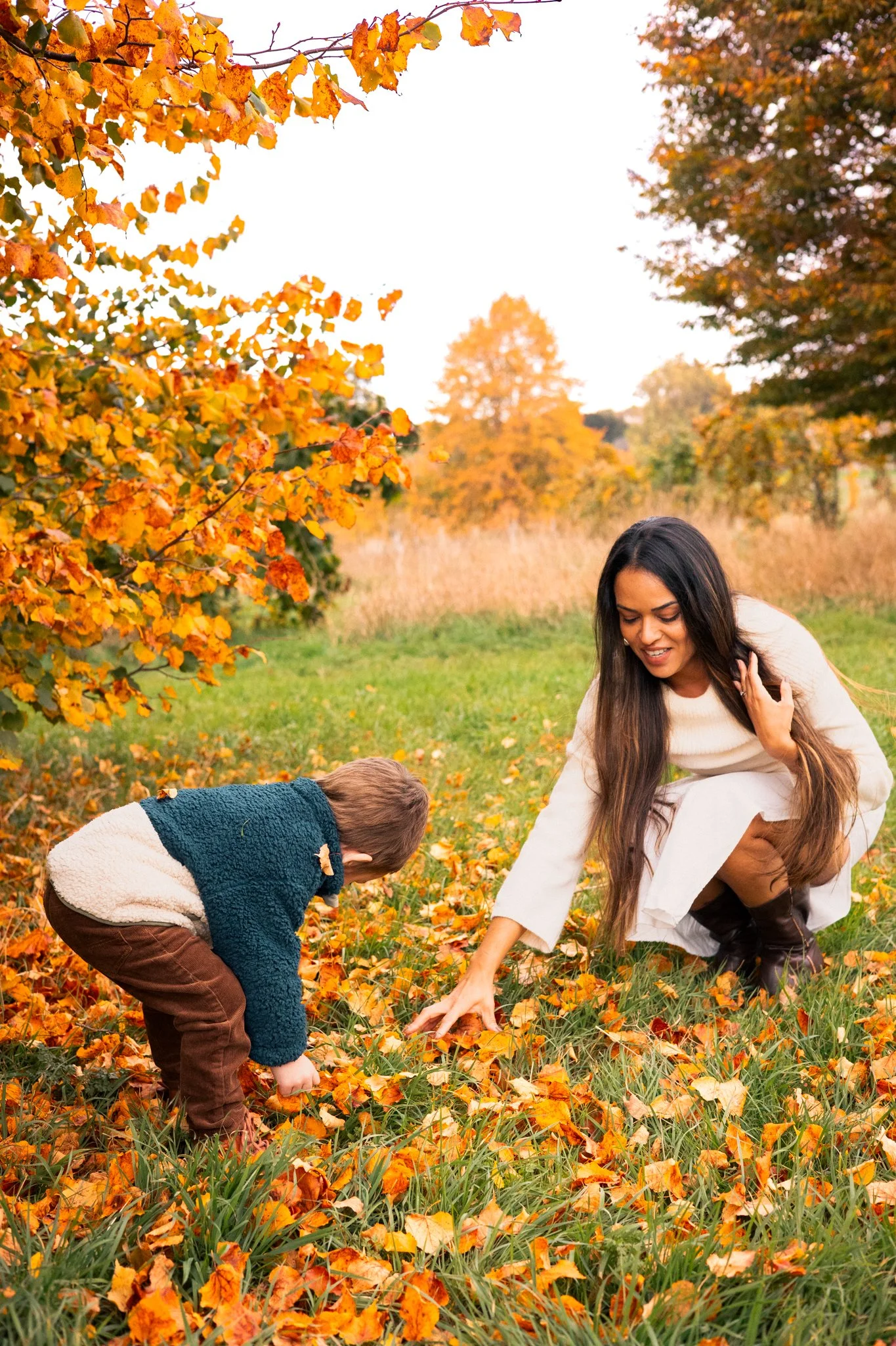 Mother and Son playing amongst Autumn Golden Leaves