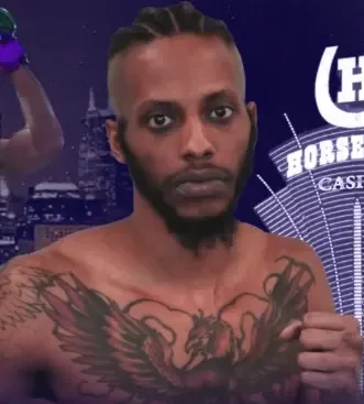 A shirtless man with braided hair and tattoos on his chest, standing in front of a neon-lit cityscape background with the word 'Borsh' visible.
