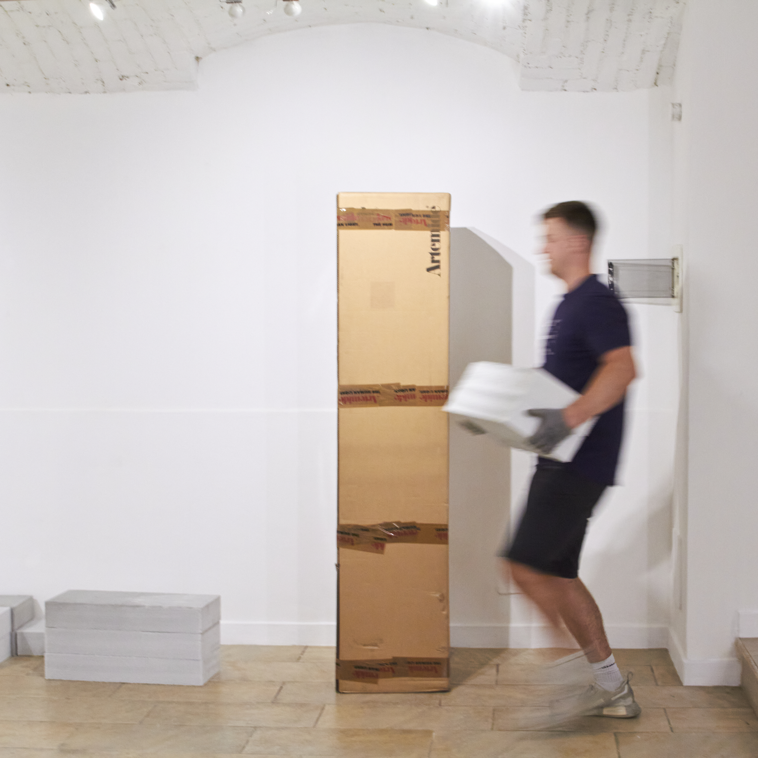 Photograph of Design Burger founder Joe Slatter carrying exhibition plinths from insulation blocks during installation at Candy Snake Gallery, Milan