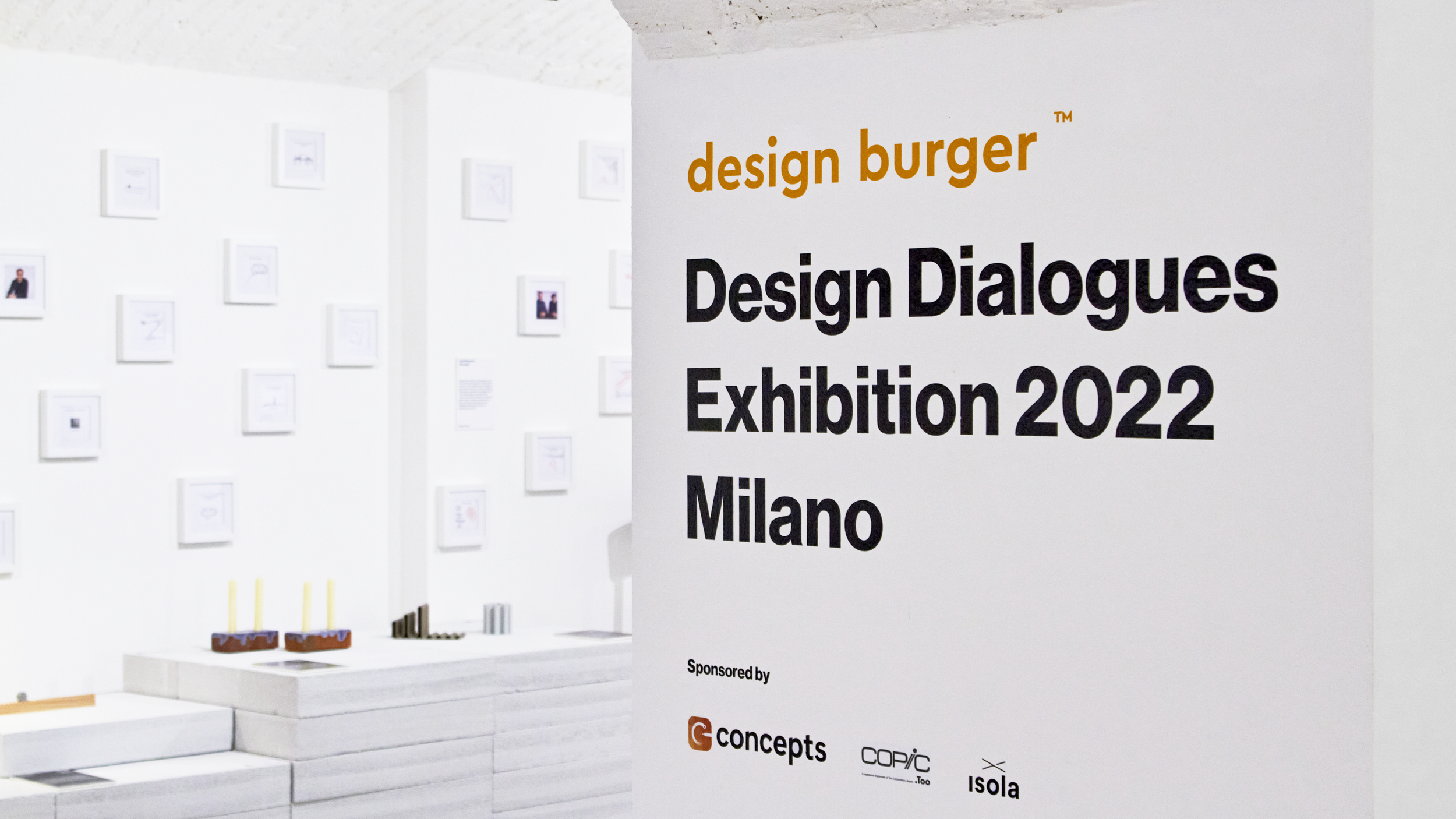 Close-up of the exhibition wall decal on the centre pillar reading ‘Design Burger Design Dialogues Exhibition 2022 Milano'