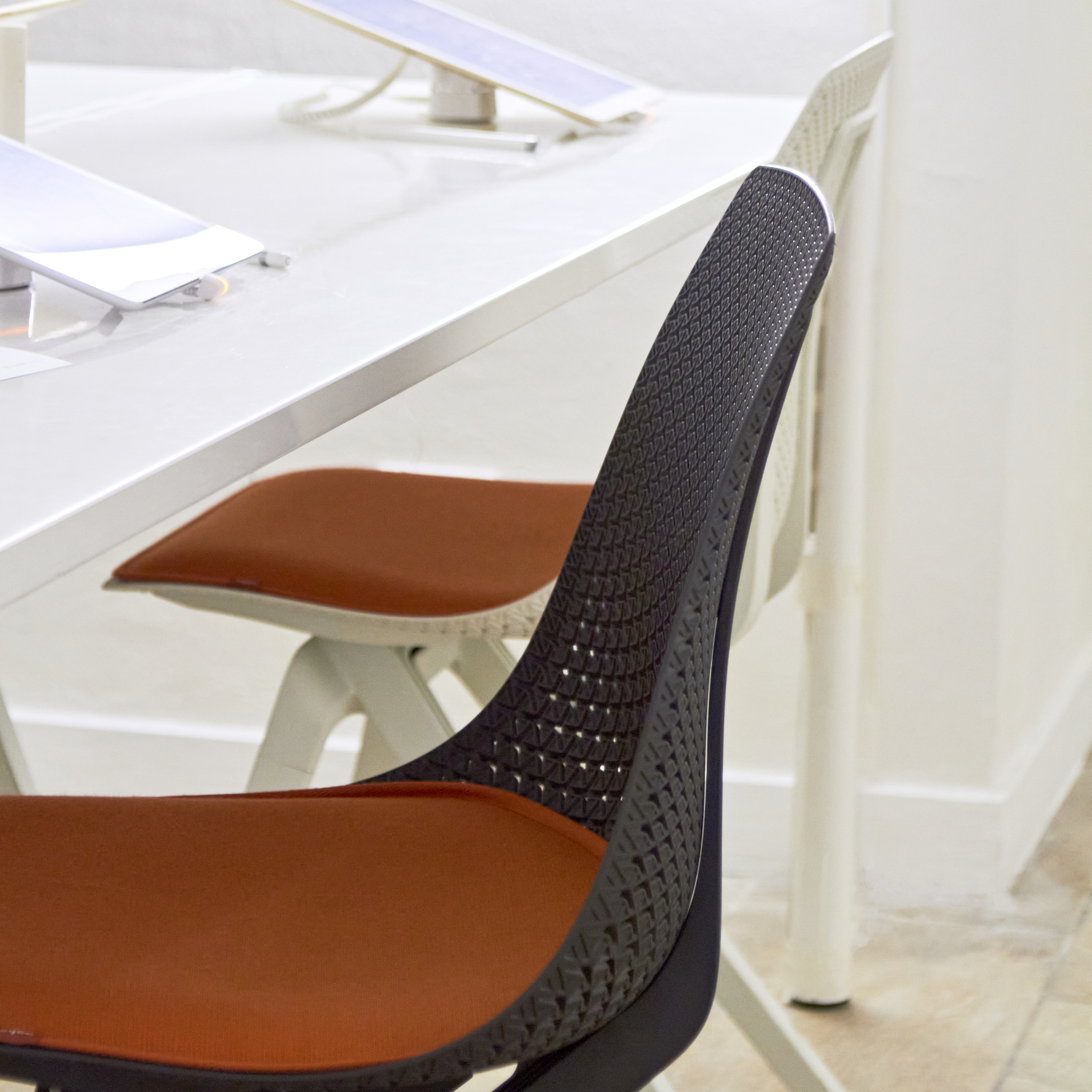 Photograph of Noho chair at the interactive table, with iPads for sketching in the background.