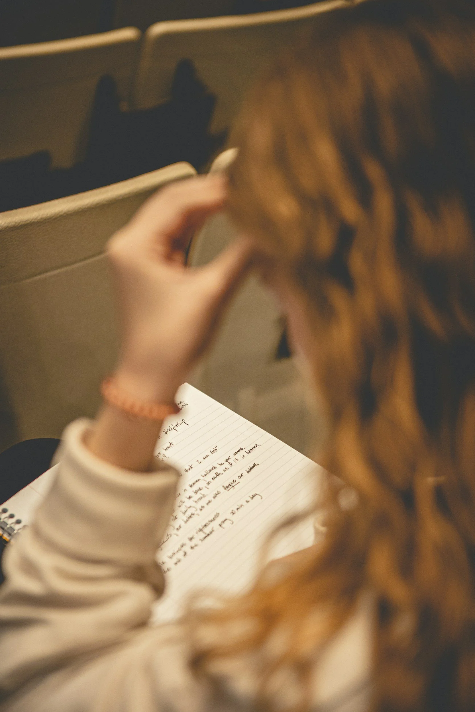 Person reading and reflecting on handwritten notes, representing focus, learning, and self-reflection.