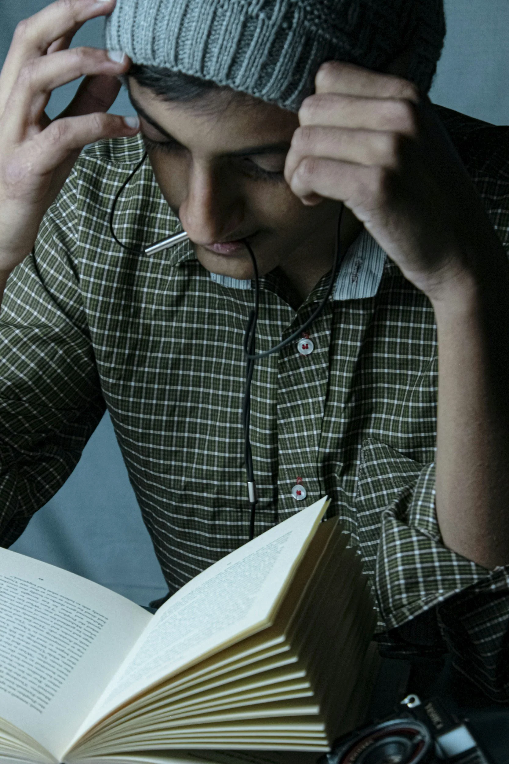 Person reading a book with a stressed expression, representing mental fatigue, focus, or overwhelm.