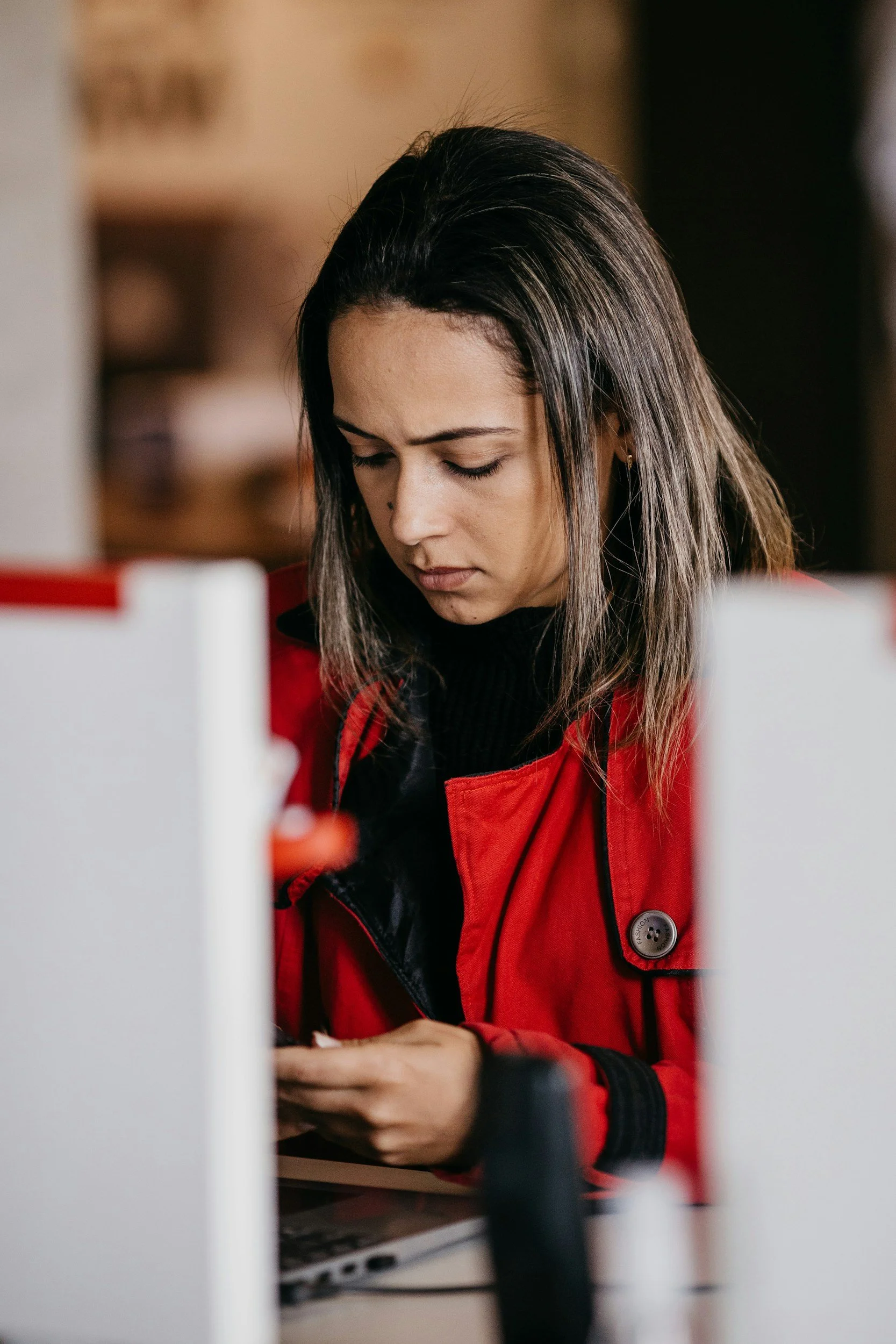 Woman checking her phone with a concerned expression, representing stress, distraction, or digital overwhelm.