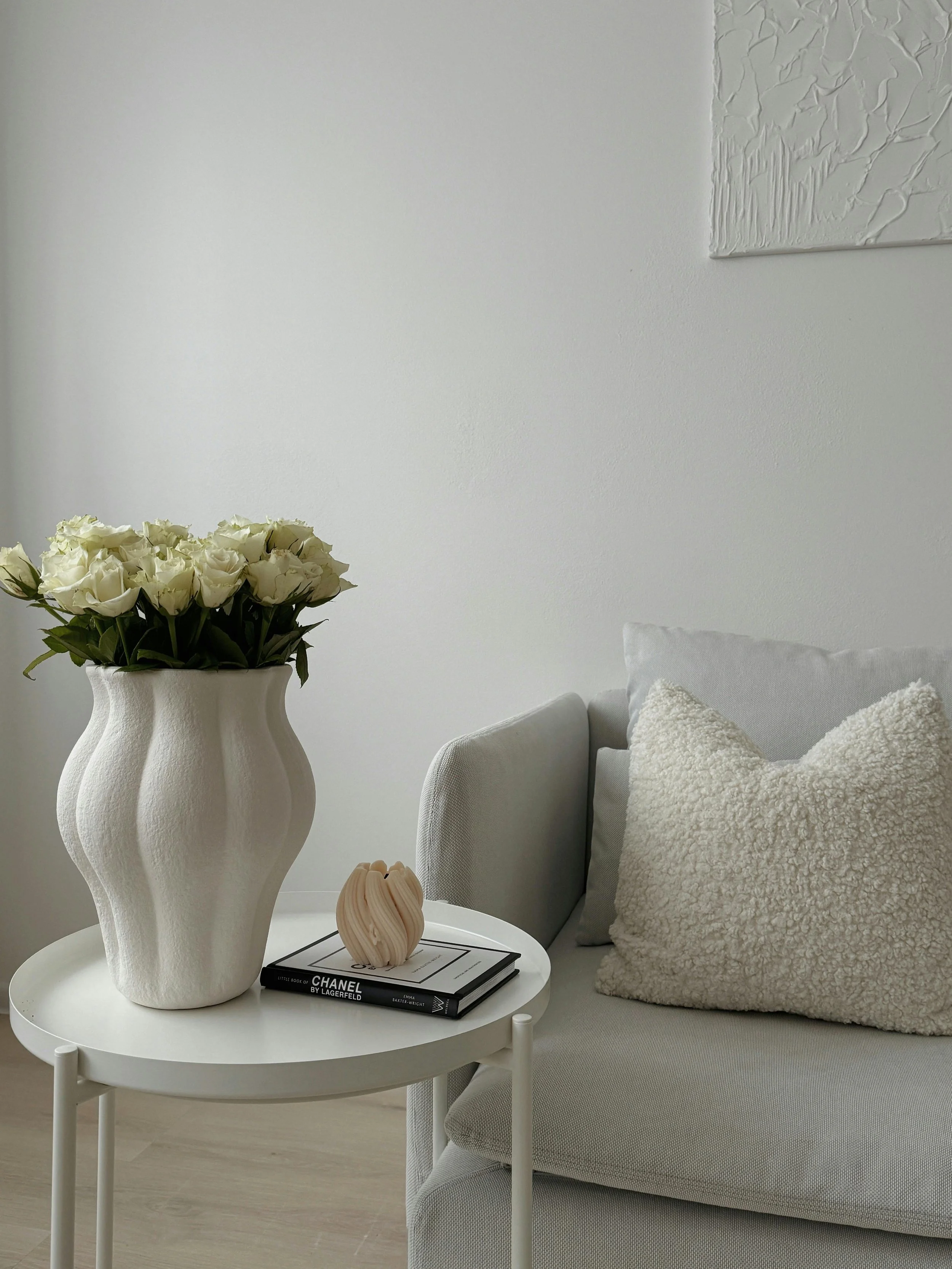 Calm, neutral living space with white roses representing comfort, softness, and a peaceful environment.