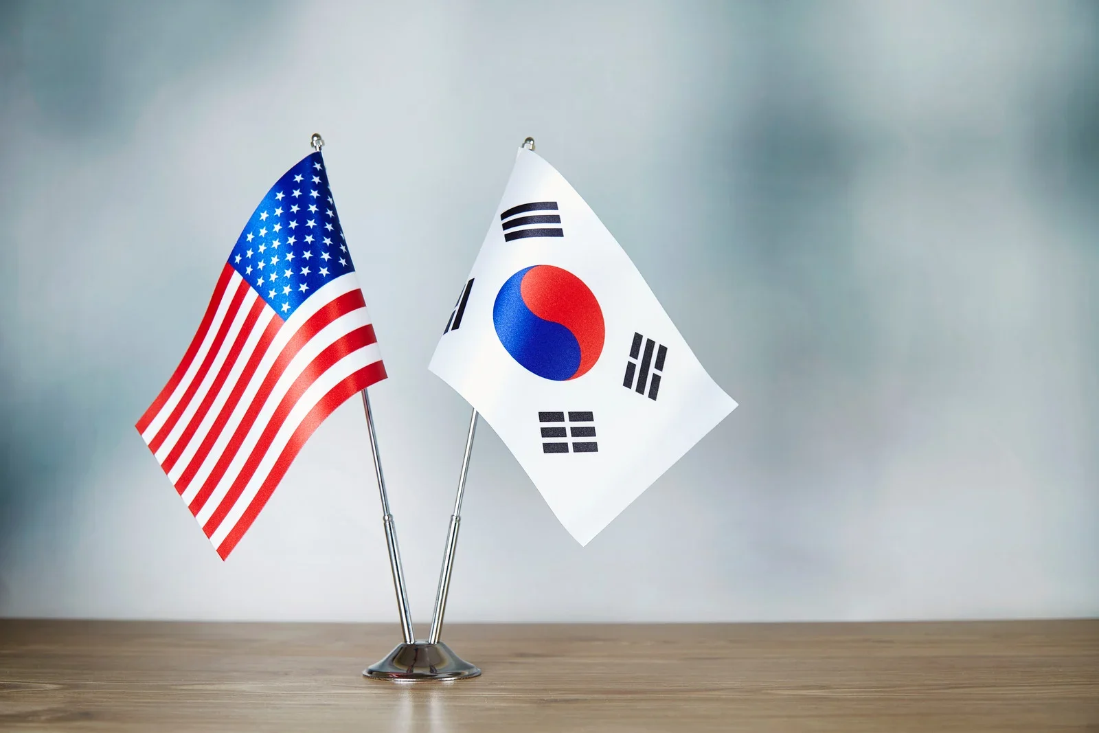 United States and South Korean flags side by side on a table, representing the Korean American bicultural experience and cross-cultural identity