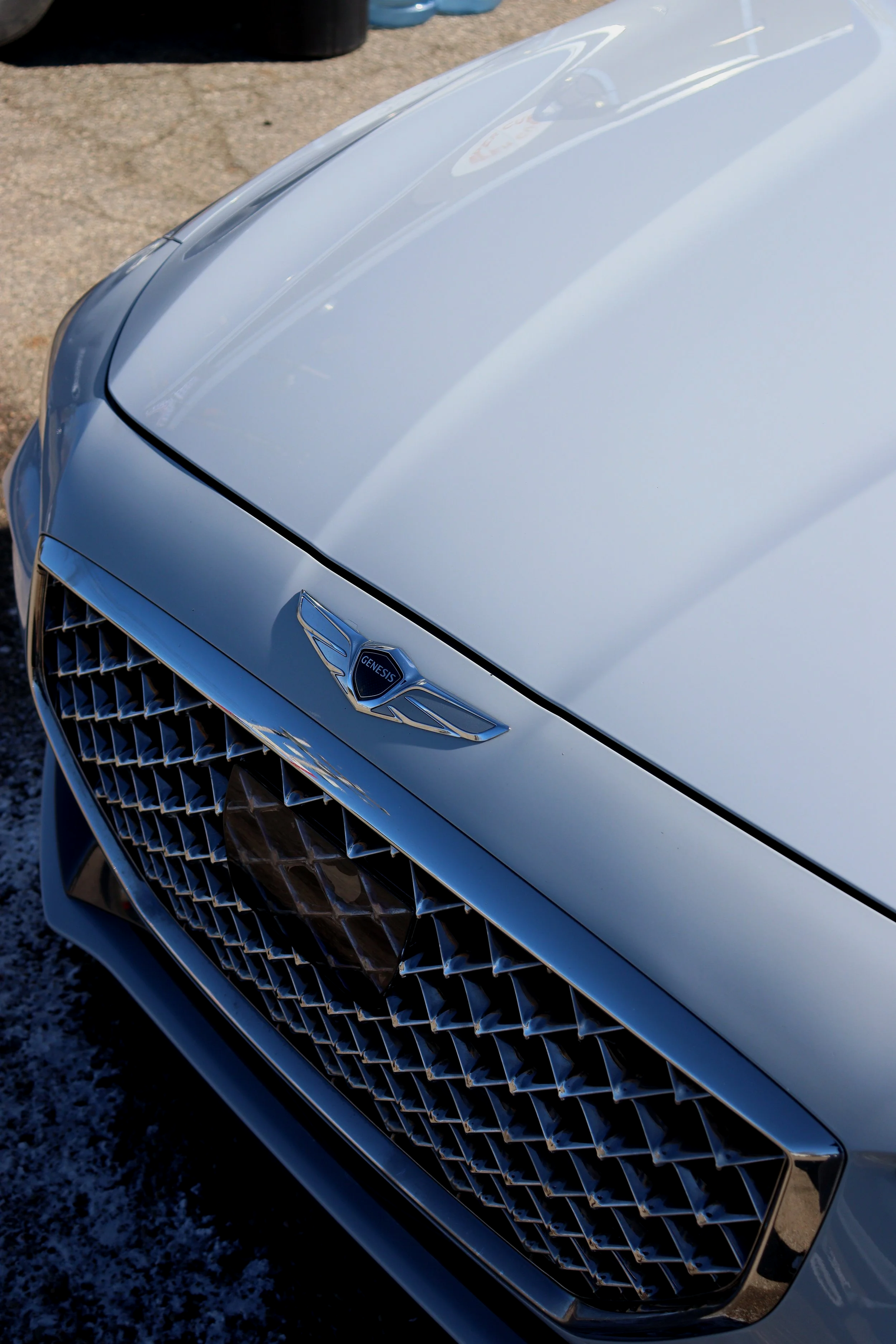 Mirror-like paint correction on a Genesis G80 in Lansing, MI, removing all swirl marks and enhancing the deep metallic flake