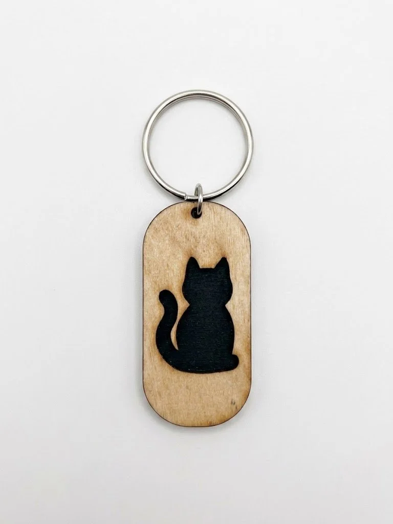 Wooden keychain with a black silhouette of a sitting cat.