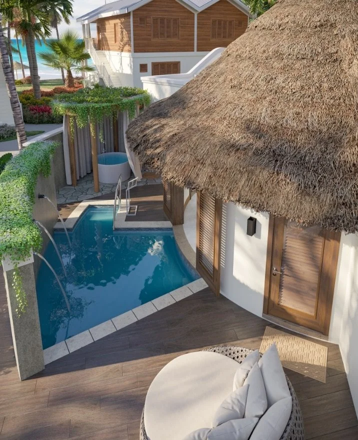 A tropical outdoor pool area with a thatched roof hut, a small pool, and lush green plants and trees.