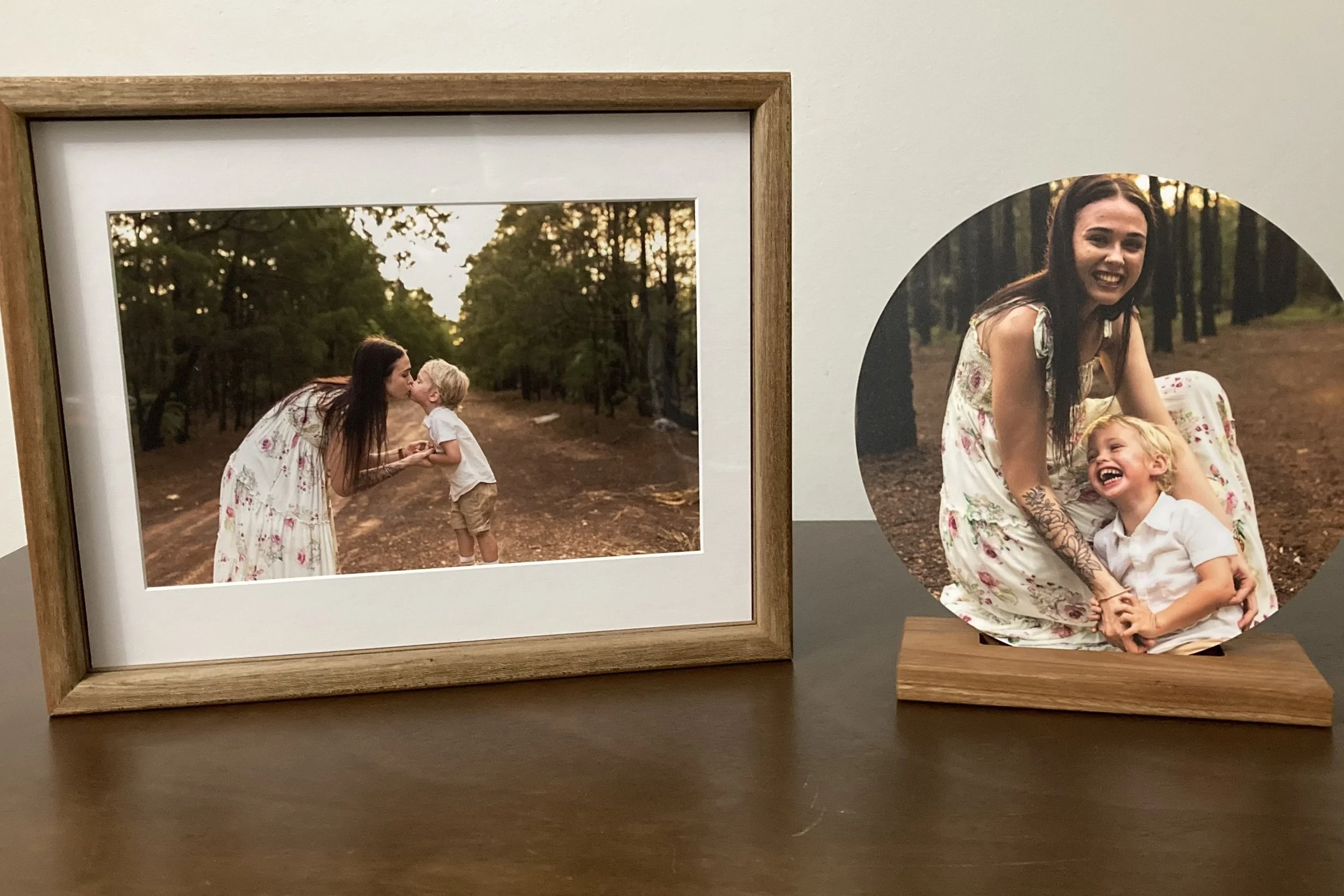 Photographs of a woman and child outdoors in a forested area, one with the woman kissing the child's forehead and the other of them smiling and sitting together.