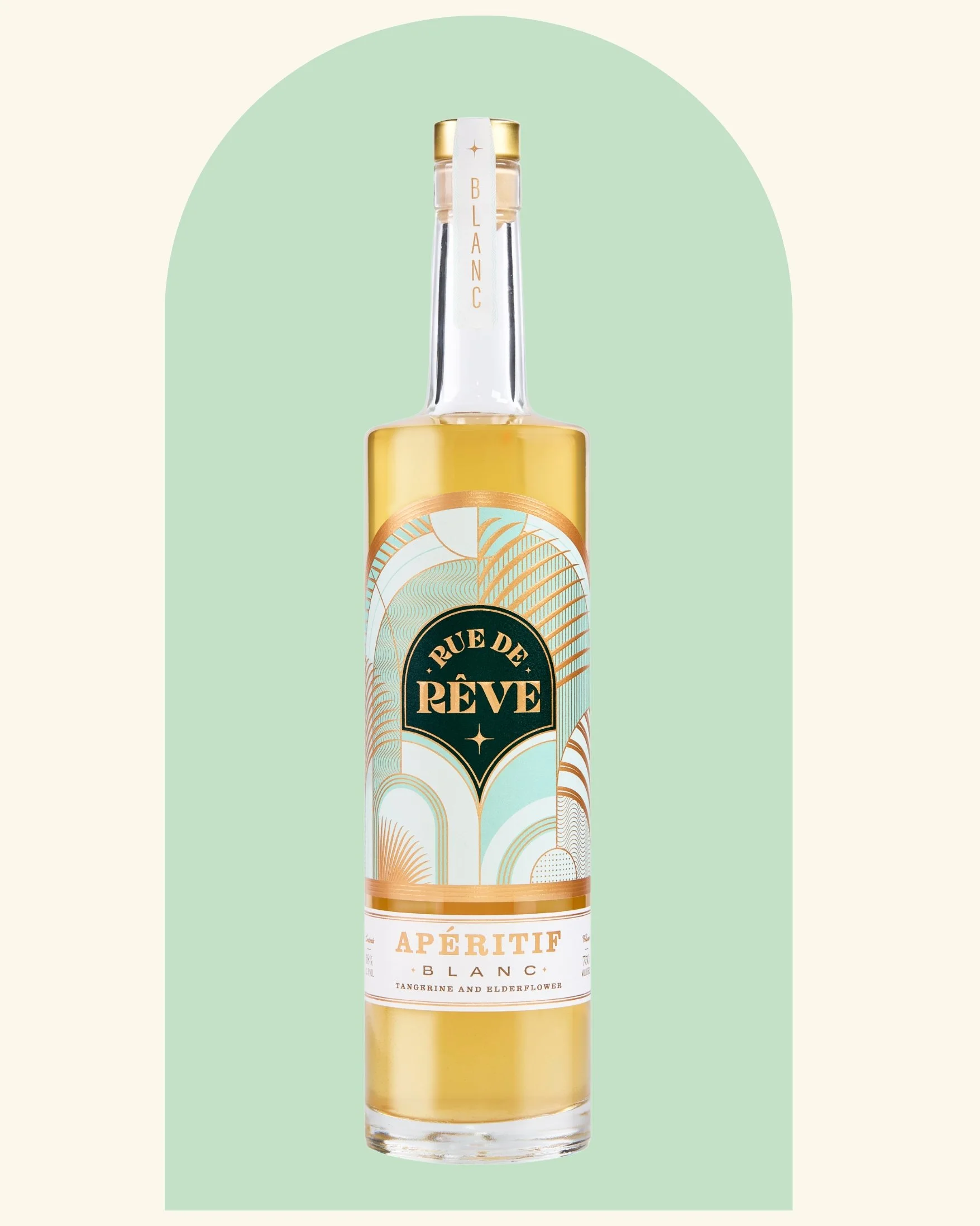 A clear glass bottle of Rue de Rêve Aperitif with tangerine and elderflower flavor, featuring a colorful label design with gold, black, and pastel accents, against a pale green background.