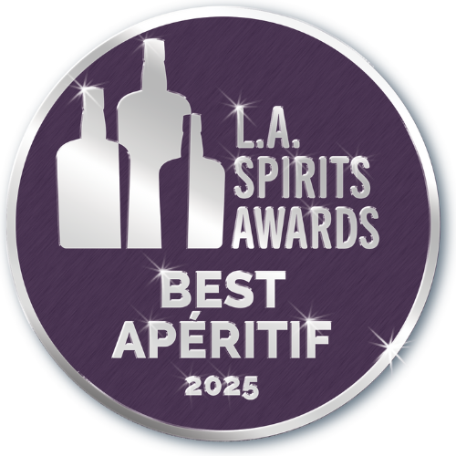 A circular logo with a purple background, featuring stylized silhouettes of three liquor bottles and text that reads "L.A. Spirits Awards Best Apéritif 2025."
