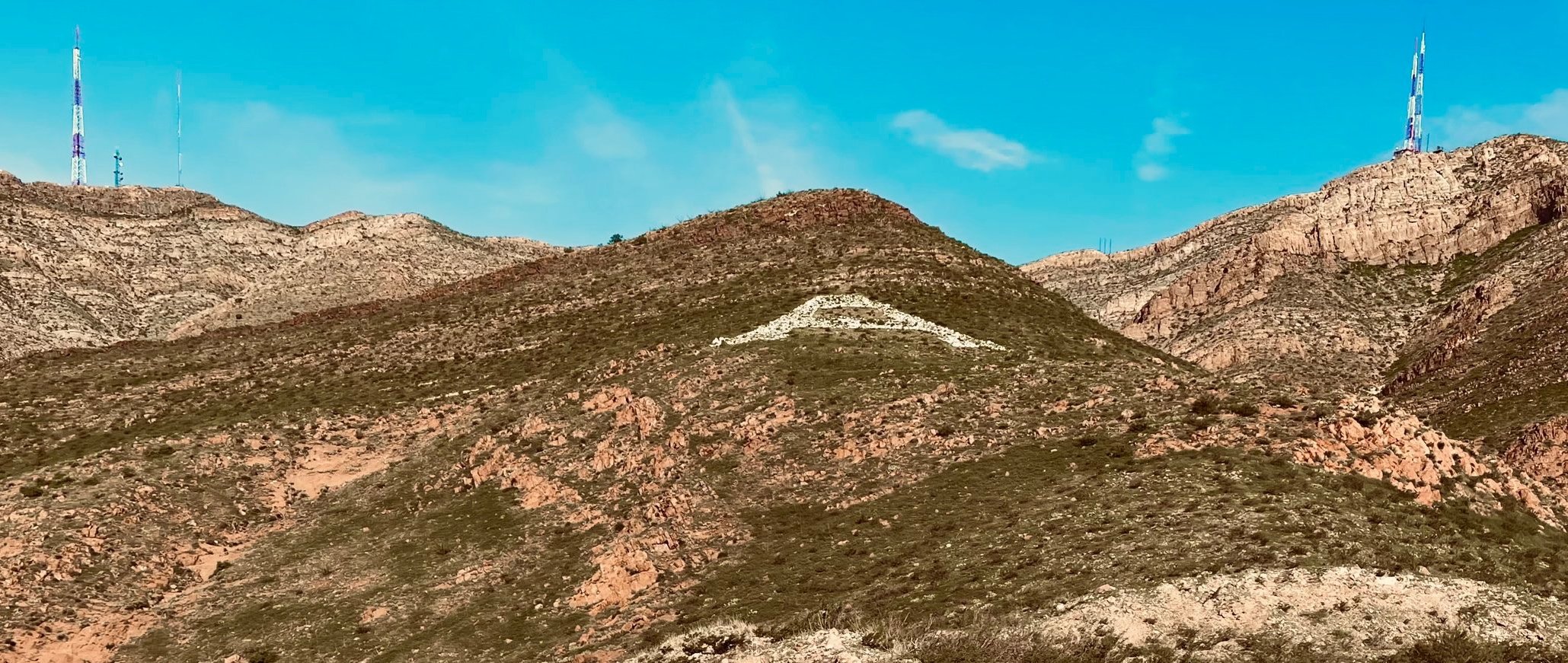 Mountain landscape with letter 'A' marked, radio towers on peaks.