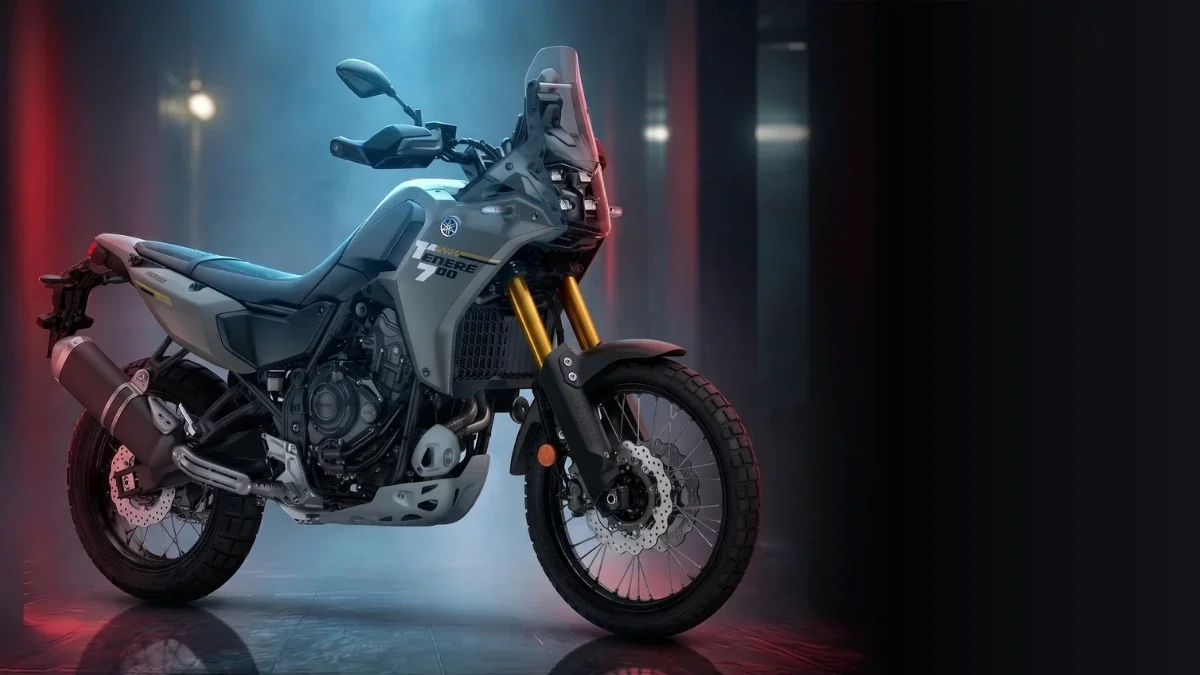 Une moto Yamaha Ténéré 700 dans un environnement sombre avec un éclairage rouge et bleu.