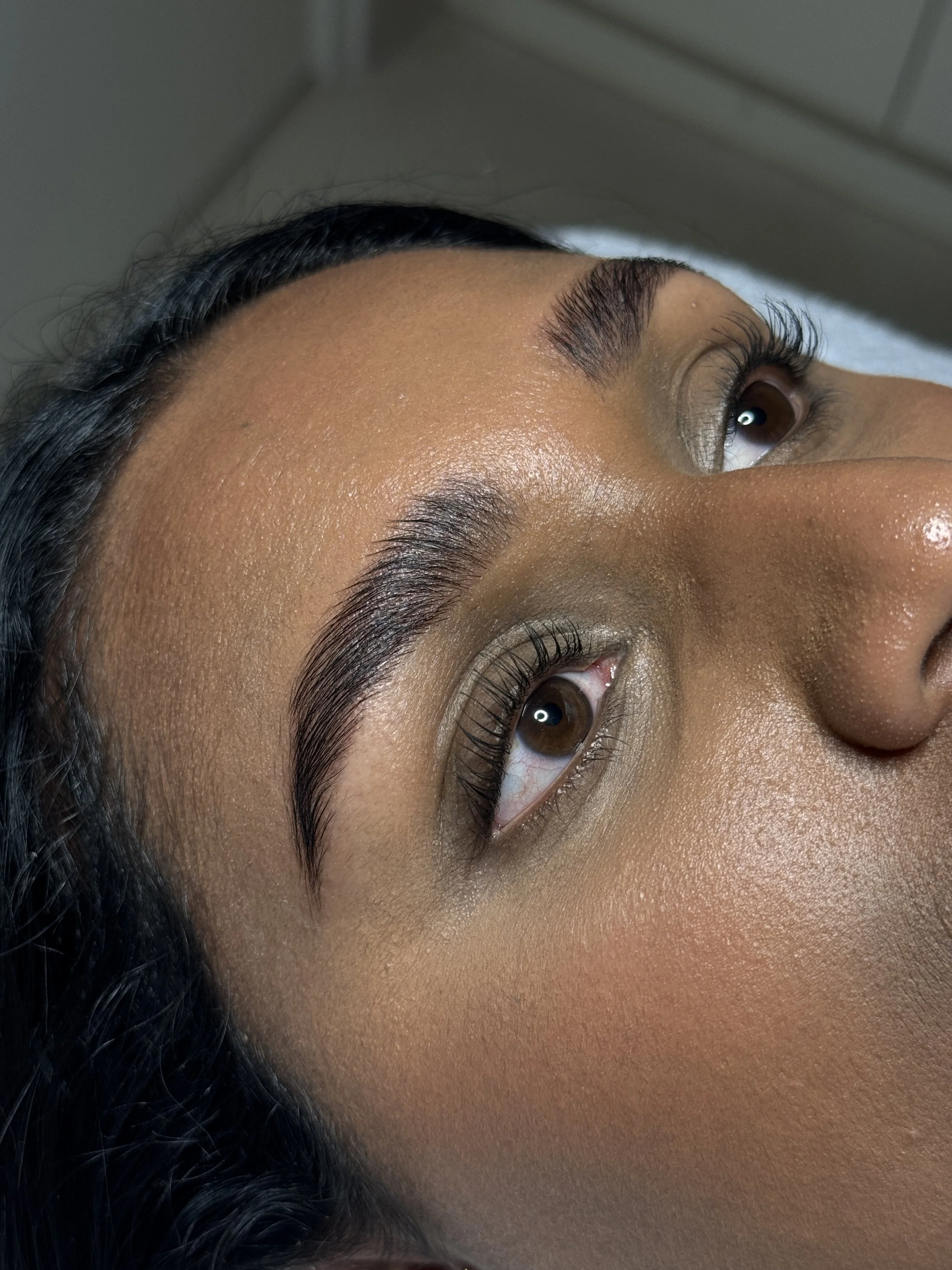 Close-up of a woman's face focusing on her eyes and well-defined eyebrows.