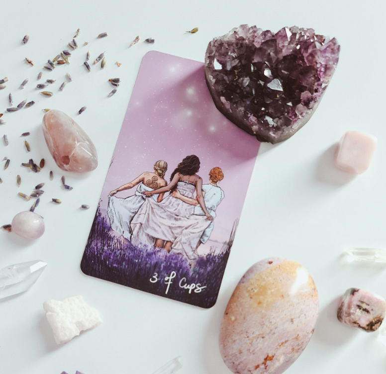 Tarot altar with tarot card deck, women gathered in a sacred space with crystals and healing energy