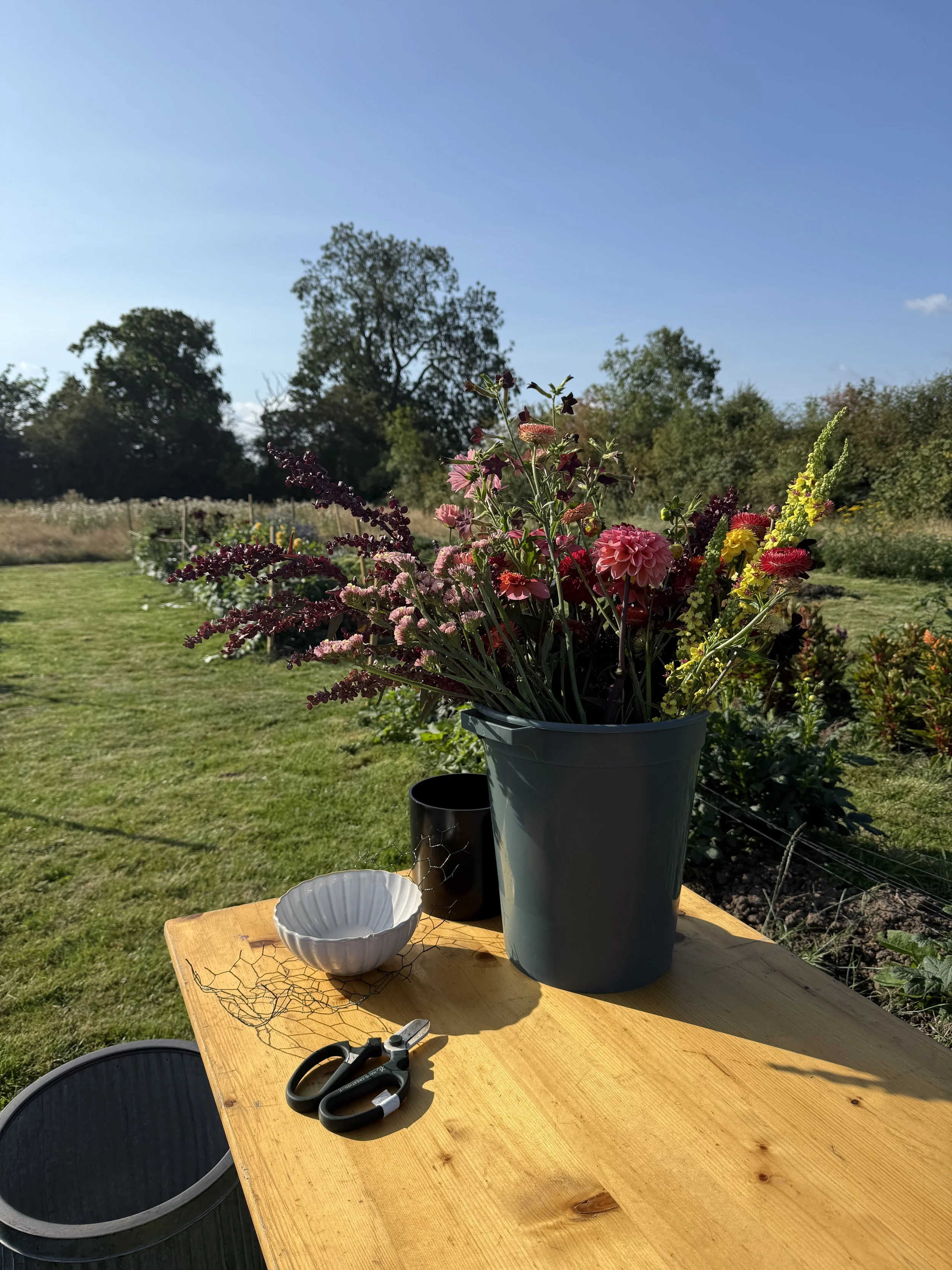 Workshop setup on a Cheshire flower farm with tables prepared for a floristry class using seasonal, farm-grown flowers.