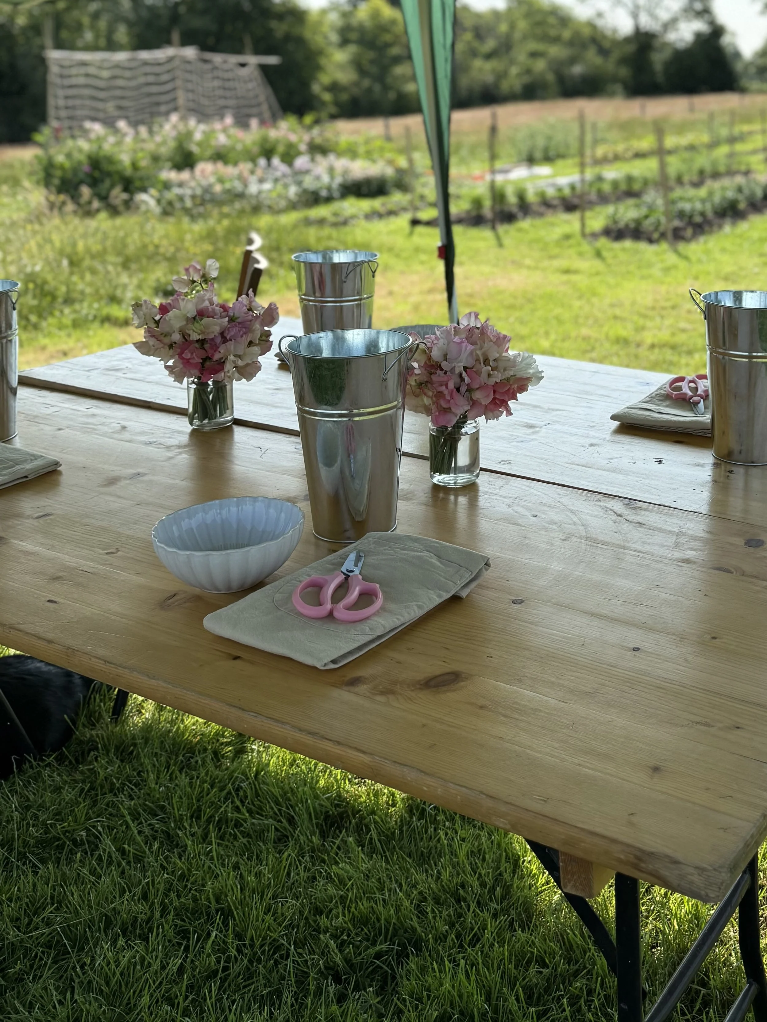 Workshop setup on a Cheshire flower farm with tables prepared for a floristry class using seasonal, farm-grown flowers.
