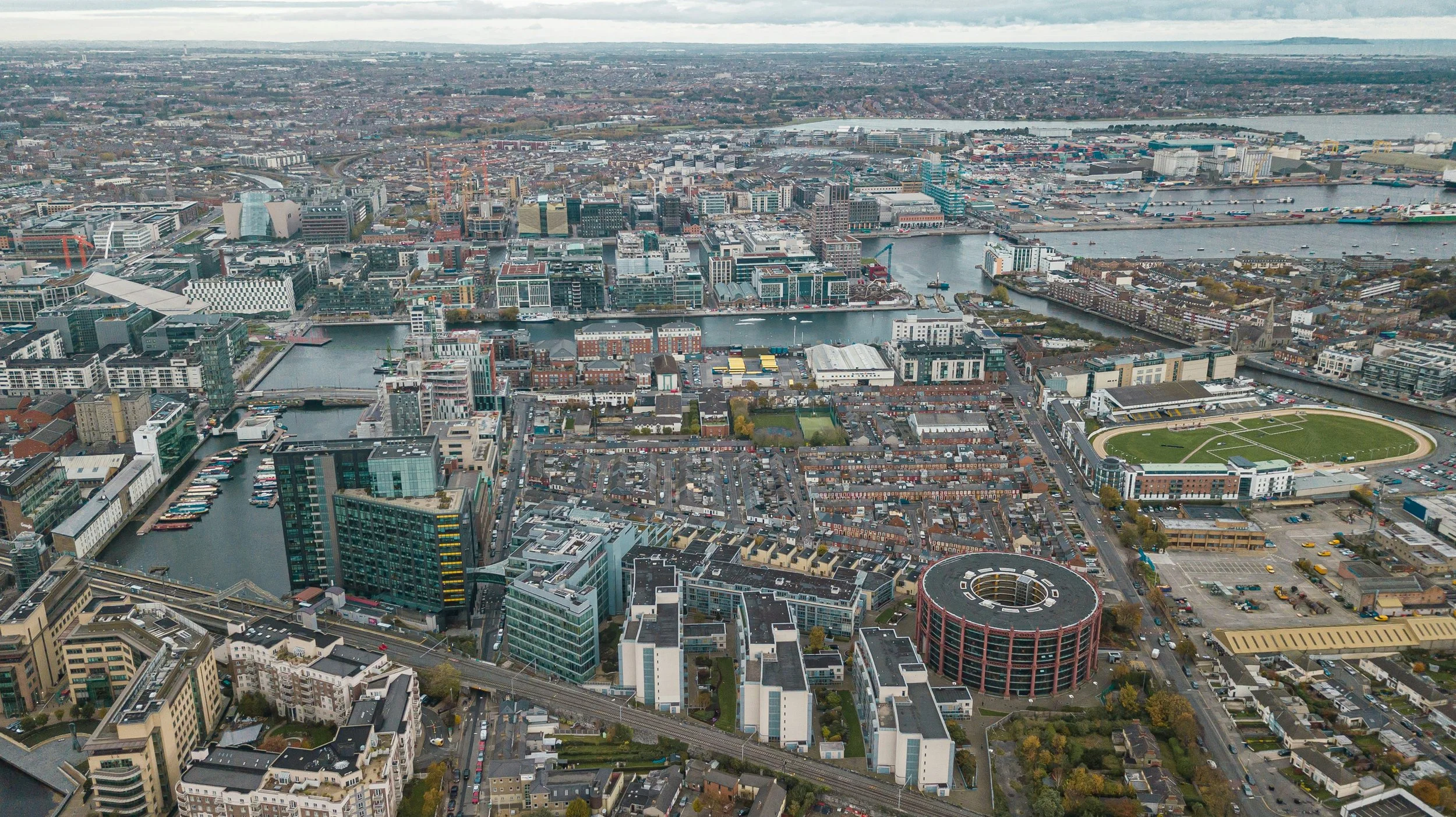 Aerial view of Dublin cityscape with River Liffey, modern buildings, and residential areas.