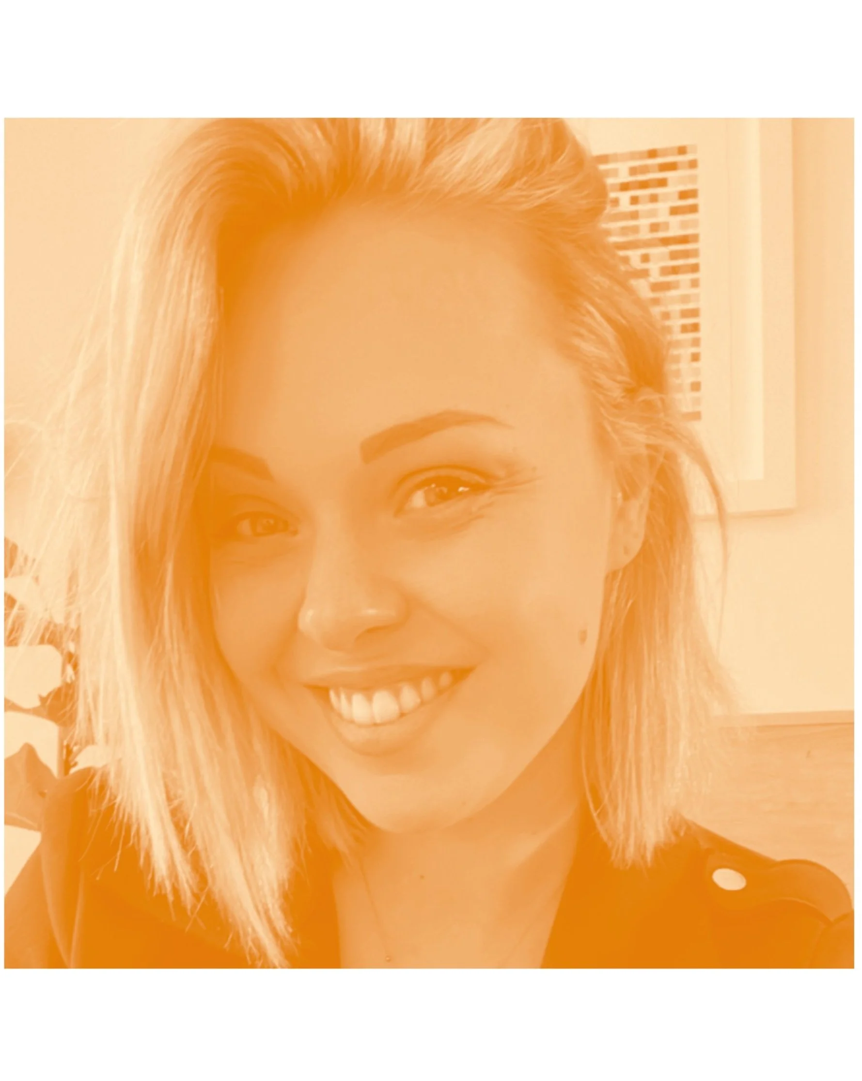 Smiling young woman with blonde hair and light skin in a close-up portrait.