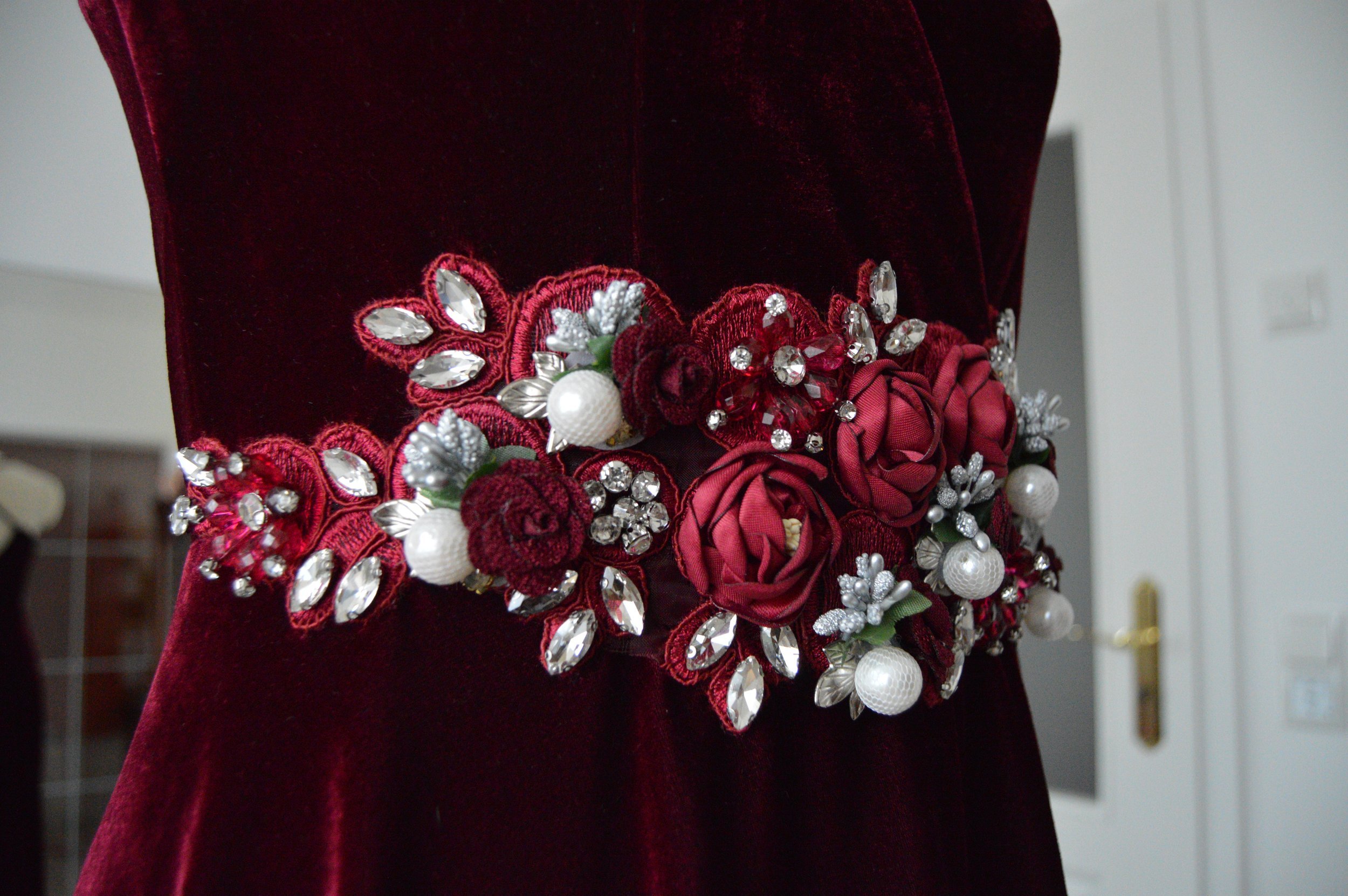 Rosenbestickung Perlenbestickung Strass florales Muster Blattmotiv Glitzersteine Abendkleid weinrot Bordeaux Gürtel Ornamente A-Linie Dunkelrot
