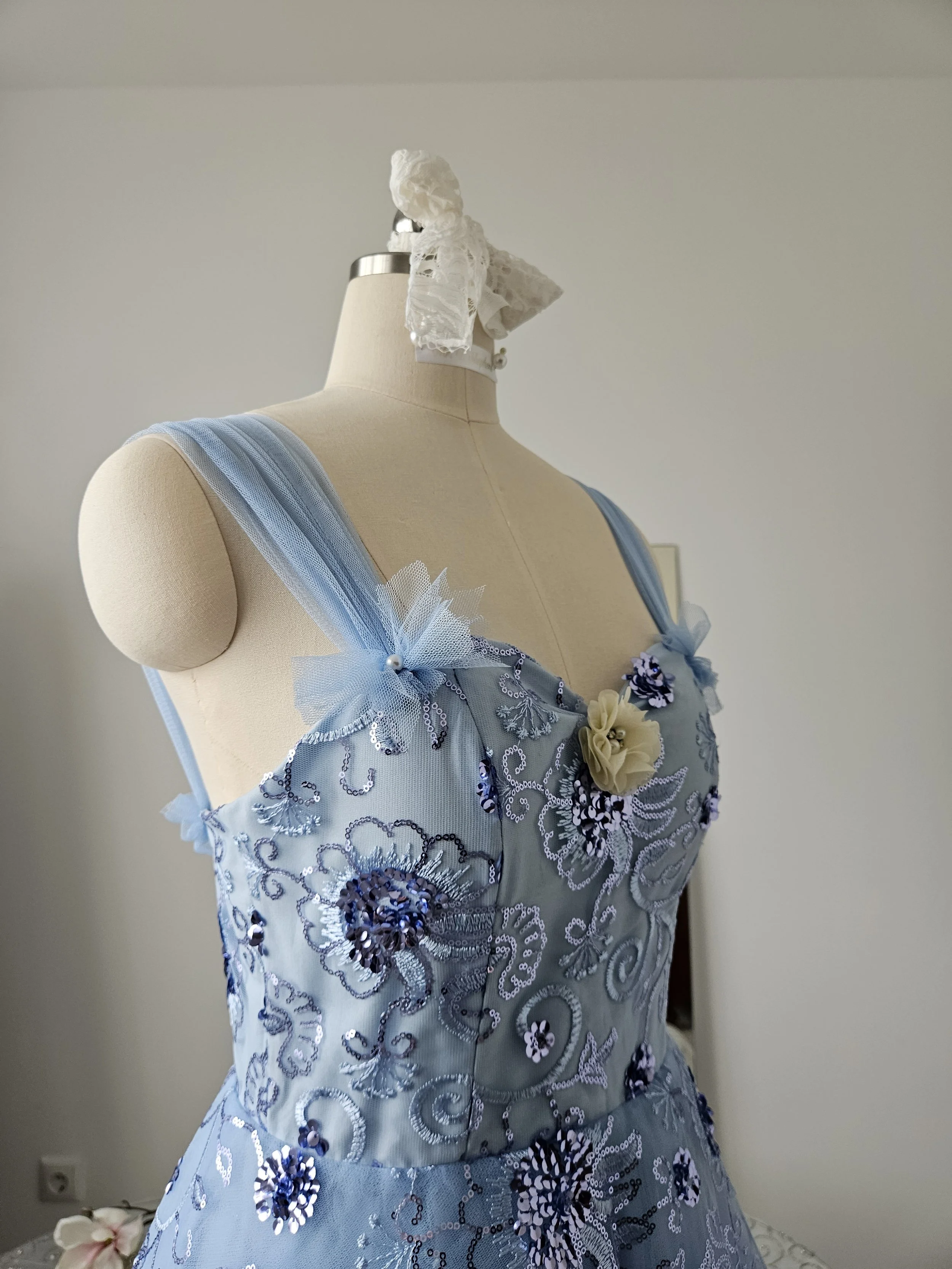 Kleid aus blauem Tüll mit floralem Glitzer und Schnörkeln, Sweetheart Neck und Trägern. Es hat Perlen und Strassornamente und ist ausladend. Schneiderei in Regensburg.
