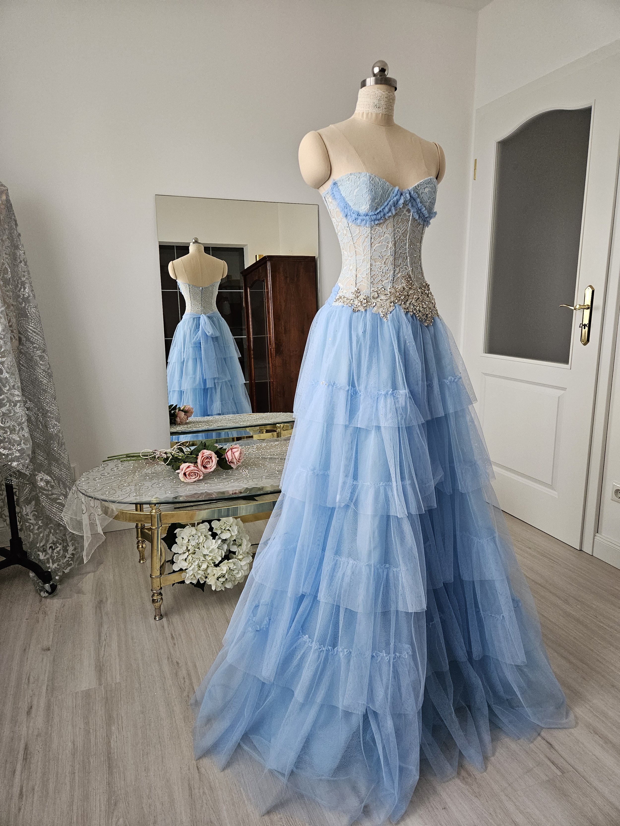 Korsettkleid aus Tüll und Spitze in hellblau / periwinkle, mit hochwertiger, glitzernder Brautkleidapplikation, mit ausladendem, abgestuftem Tüllrock in Bodenlänge. Couture-Kleid als Brautkleid