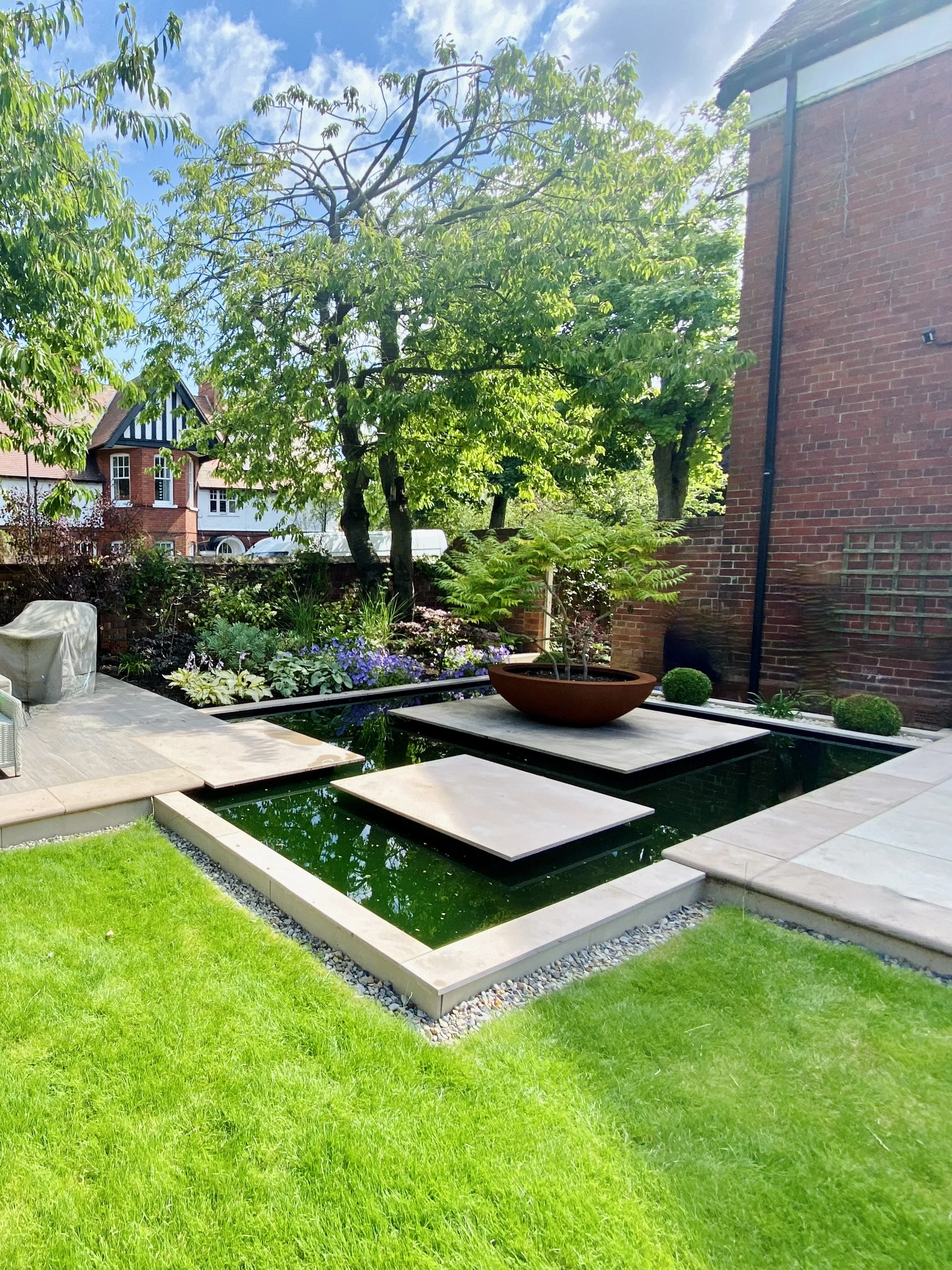 A photograph of the reflecting pool with oversize stepping stone islands linking the main patio and al fresco dining area