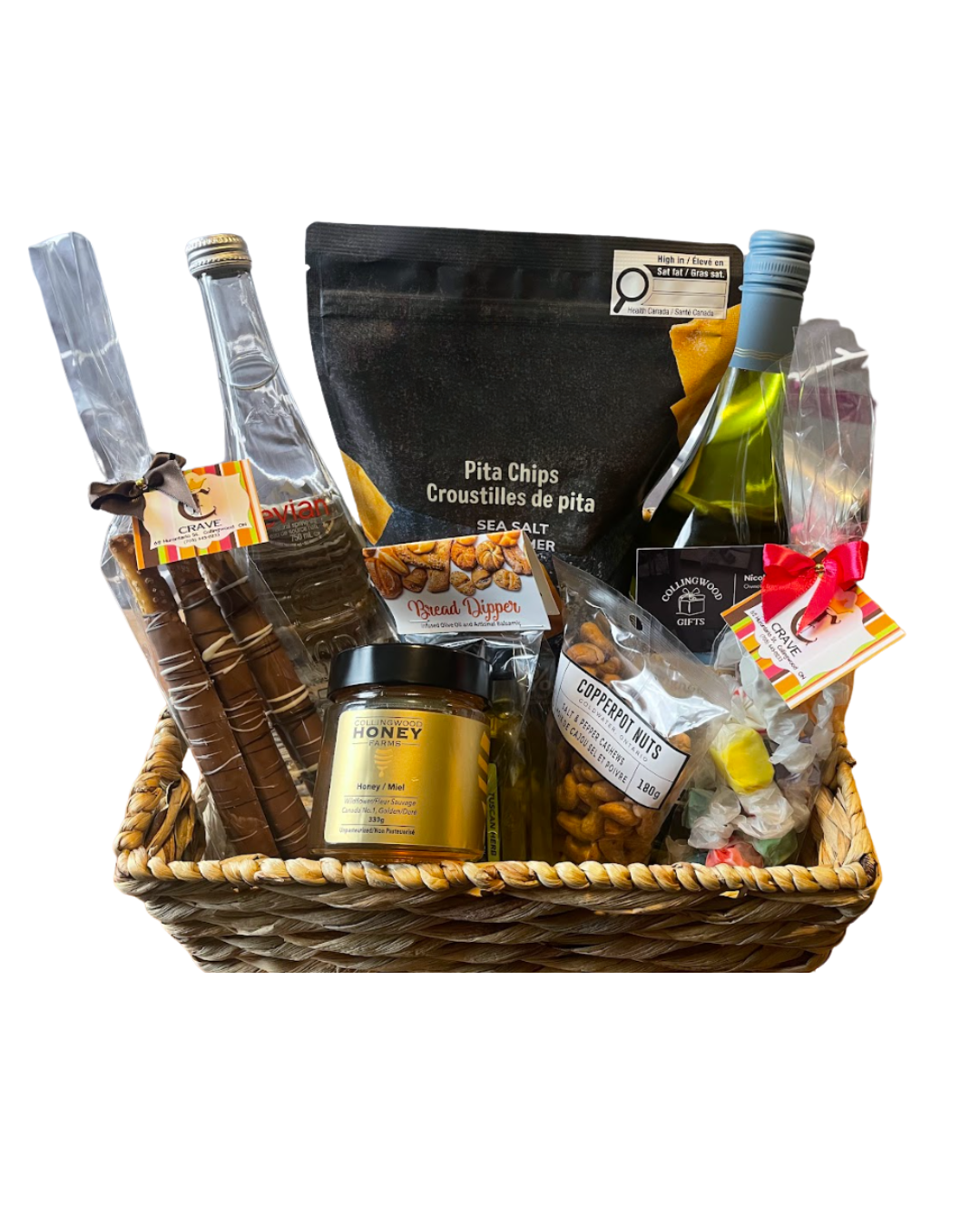 A gift basket containing assorted snacks, a jar of honey, bottles, and small wrapped items decorated with ribbons.