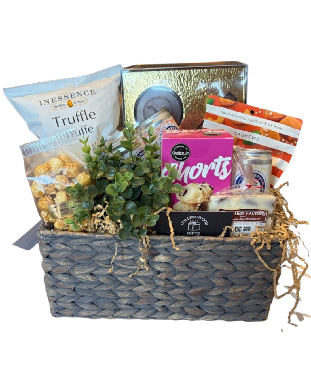 Gift basket with specialty snacks and beverages from locally owned shops and a small plant inside a woven basket.