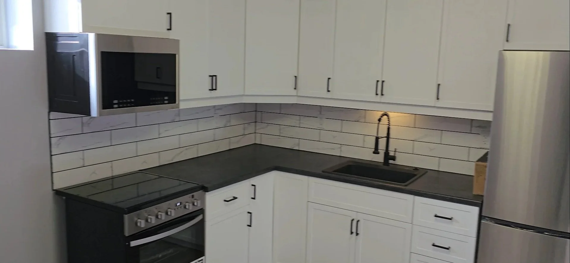 Functional basement kitchen with granite counters, subway tile backsplash, undermount sink and soft close doors and drawers