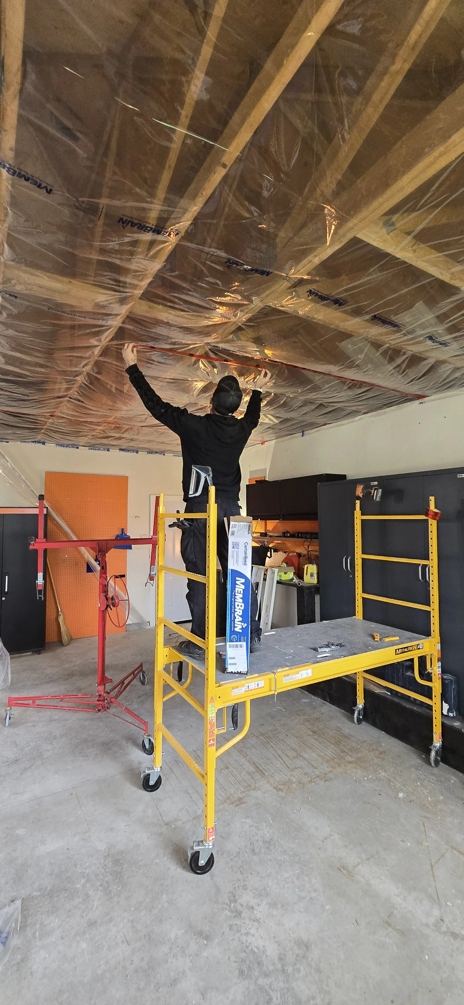 Image showing our installation of Membraine intelligent vapor retarder instead of the standard poly plastic, which was part of the moisture issue in this garage.