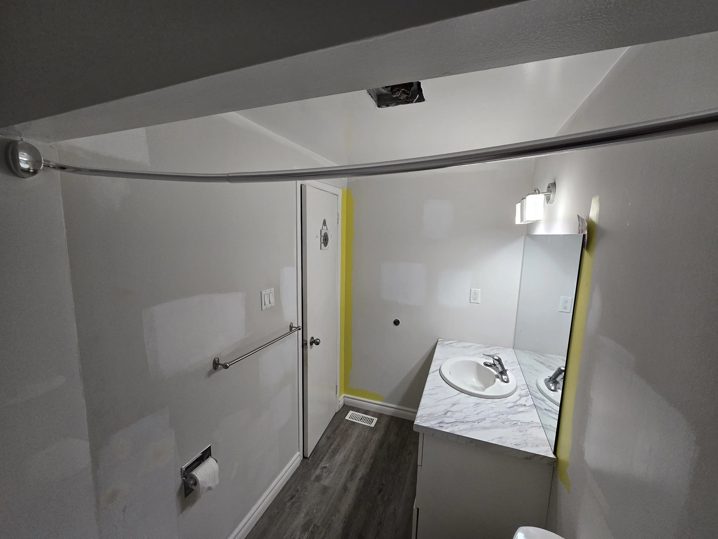 Bathroom renovation in progress in London, Ontario showing drywall repairs, wall preparation, ceiling restoration, and vanity refurbishment before painting and finishing by Peckham Professional Contracting.