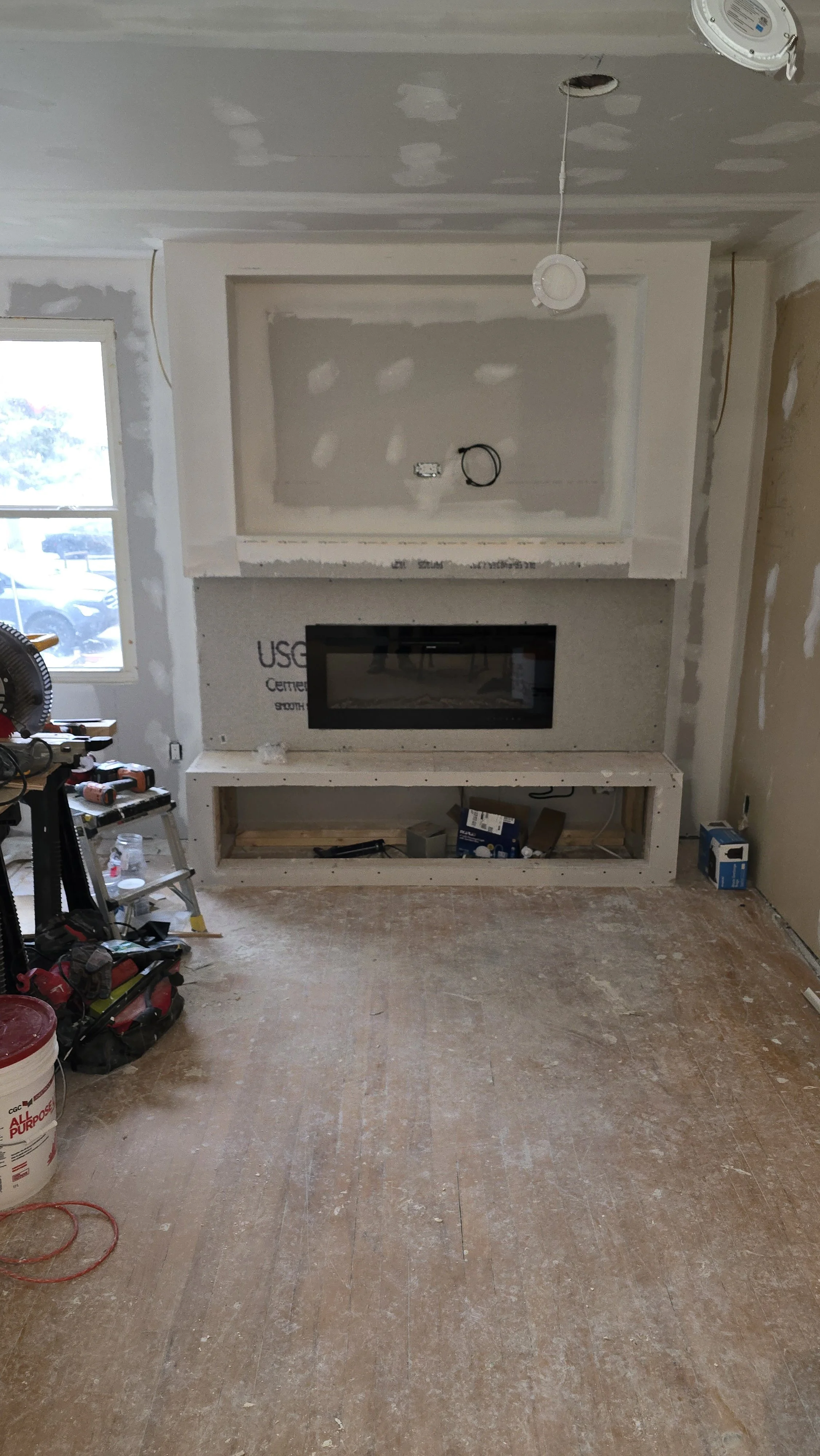 This picture shows a recent drywall install in a living room with a custom feature wall