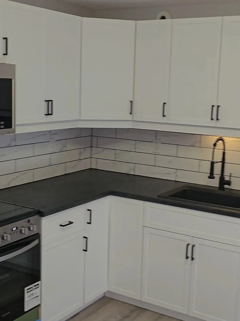 Basement L-Shaped Kitchen with subway tile backsplash, granite counters and undermount sink