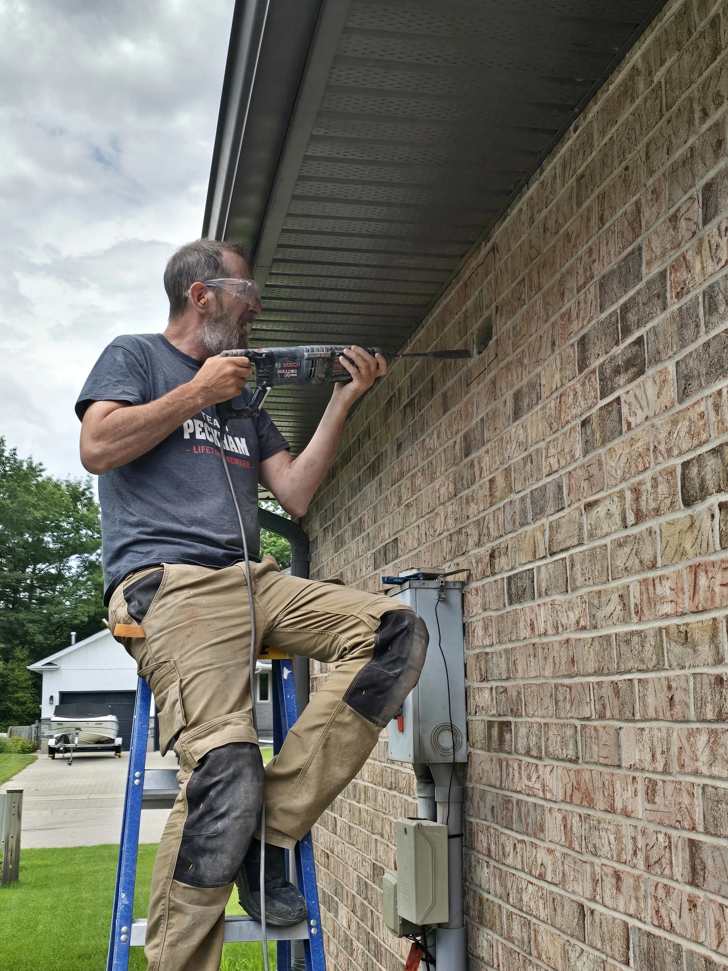 Image showing buisness owner Steve Peckham cutiing through garage brick in order to install hi-tech exhaust system to aid in humidity and temperateure control