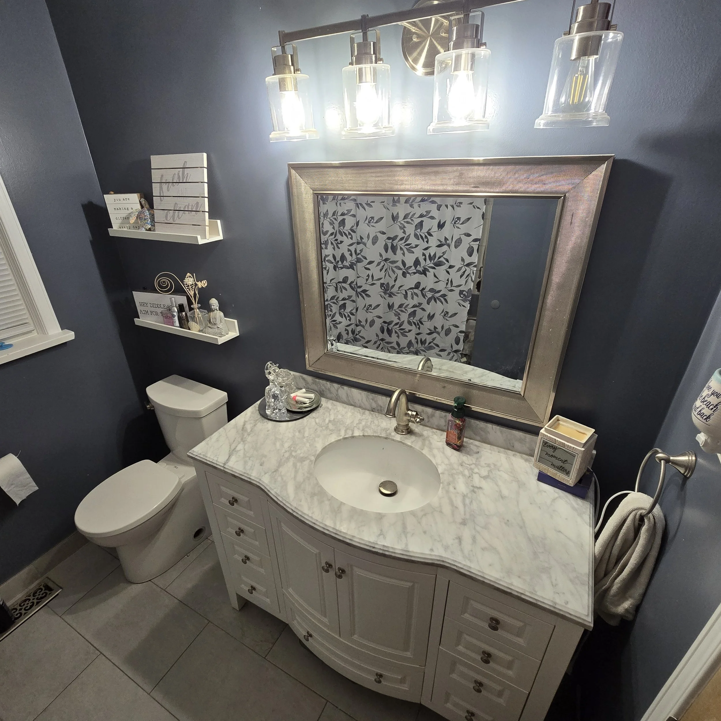 Picture of bathroom renovation on Park Ave in London. 8-drawer vanity with quartz counter, undermount sink, matchin mirror and lighting, new toilet and shelving. Paint is bathroom grade; color is 'Yacht Blue' by Behr paints.