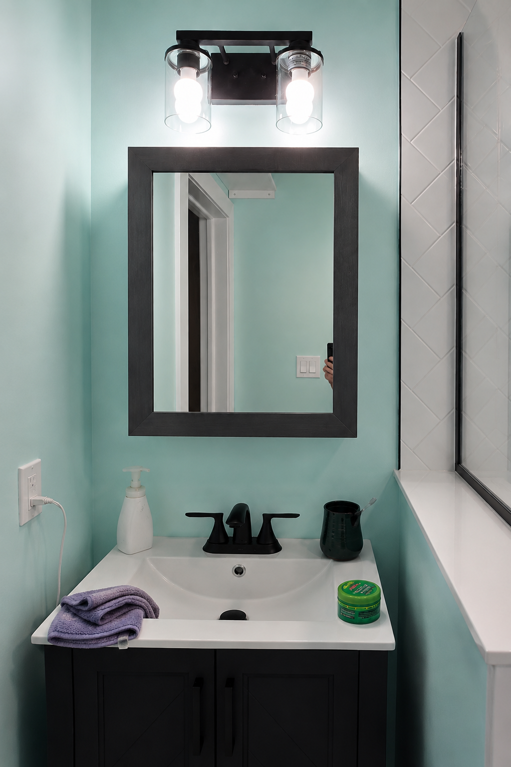 Bathroom vanity with black framed mirror and matte black fixtures