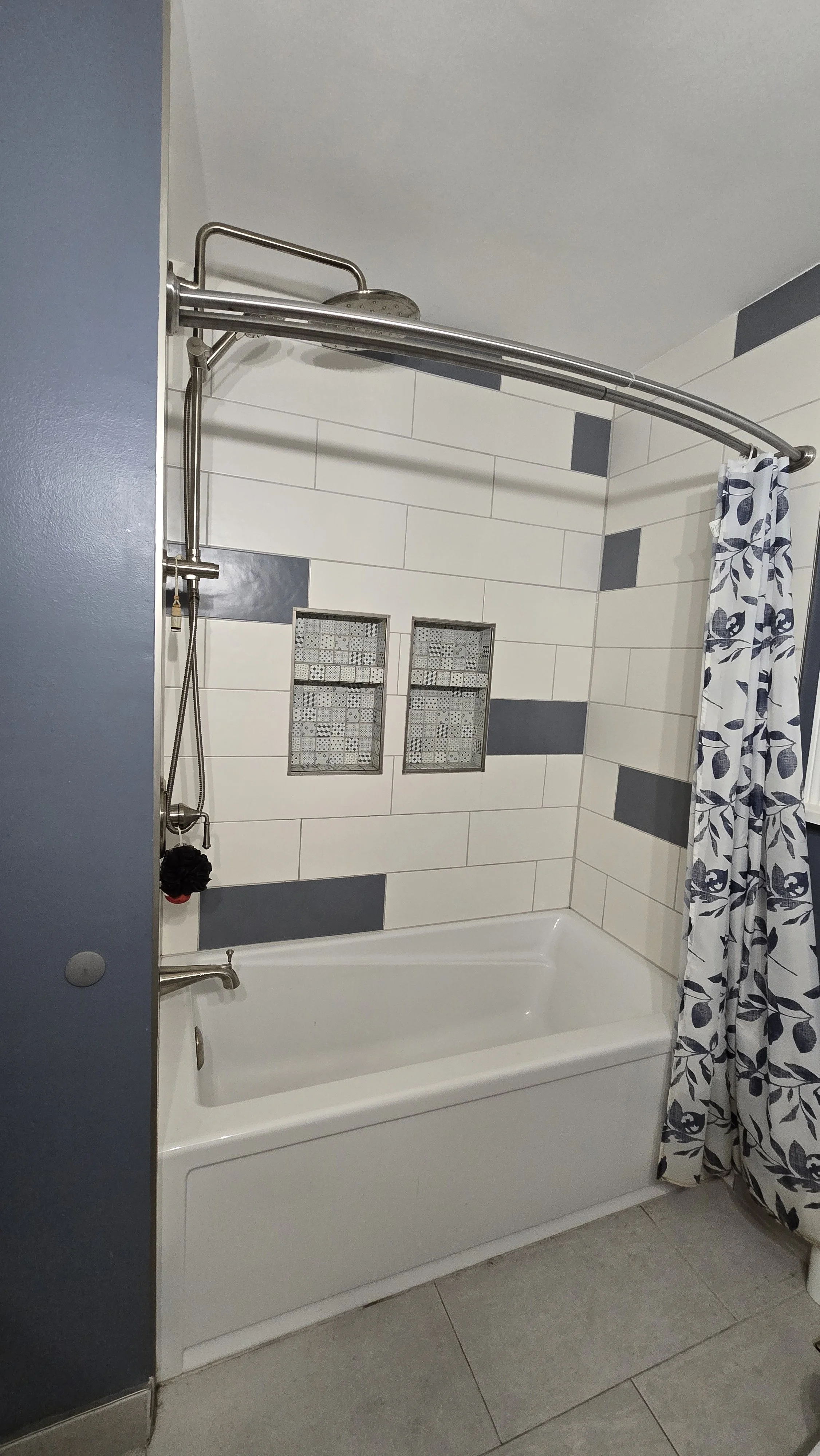 Image showing new bathtub install and shower tile design with blue and white large subway tile and double niche for shower accessories