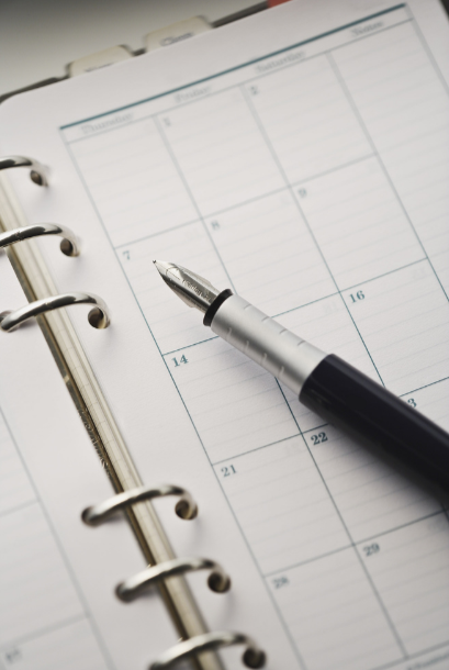 Une page de calendrier dans un agenda avec un stylo noir posé dessus.